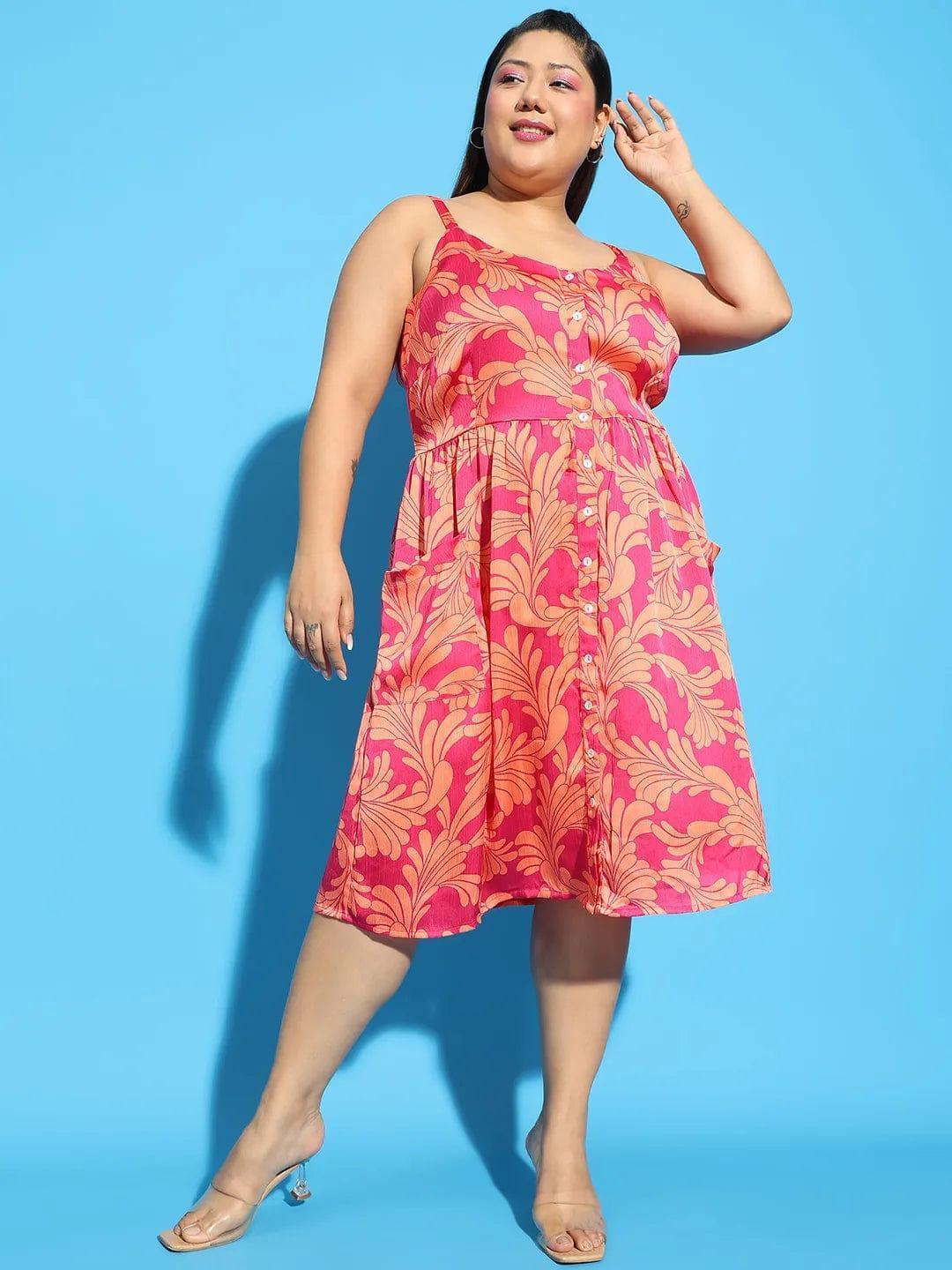 A woman wearing a pink floral print dress and holding a white purse stands against a white background.