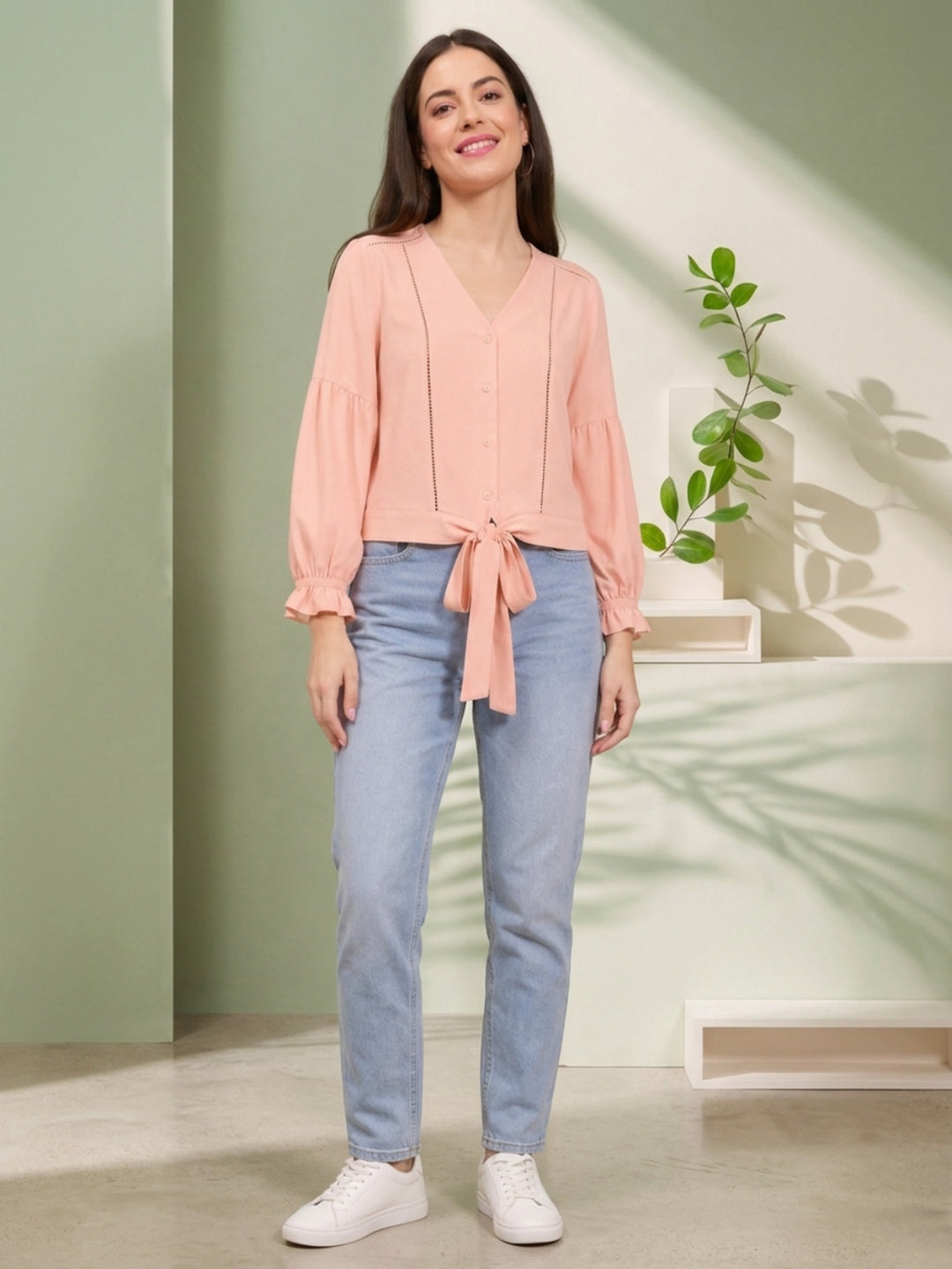 Pink tie-front blouse with puff sleeves paired with light blue jeans and white sneakers