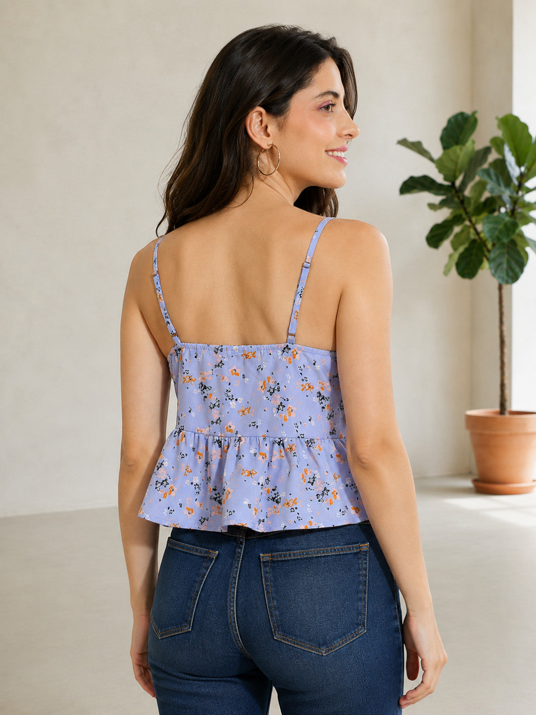 Lavender floral peplum top with thin straps, paired with dark denim jeans, stylish women's fashion