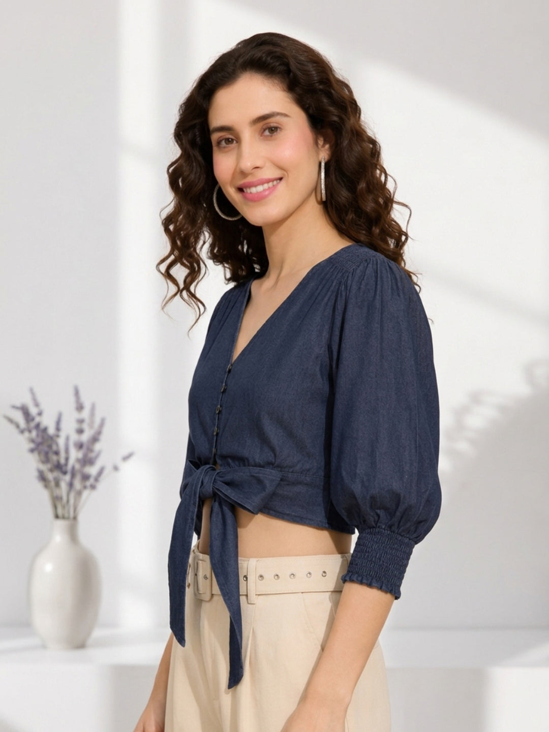 Navy blue tie-front crop top with puff sleeves, paired with beige high-waist pants for women's fashion.