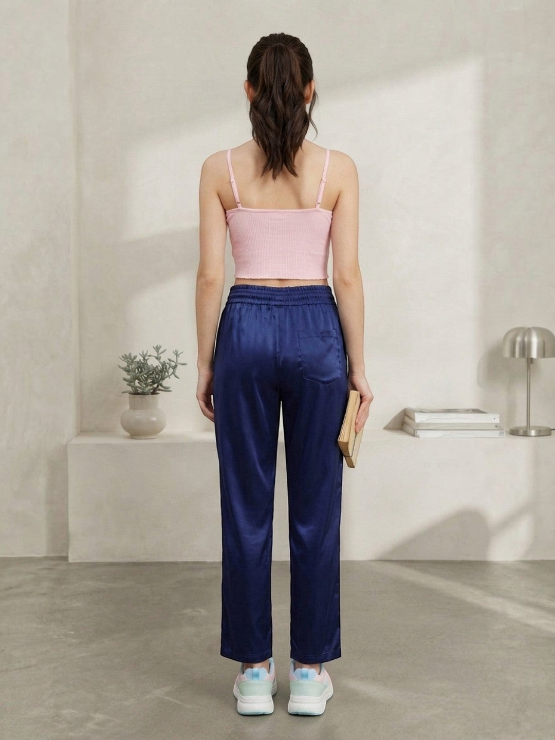 Woman in pink crop top and navy satin pants, back view, casual plus size fashion outfit