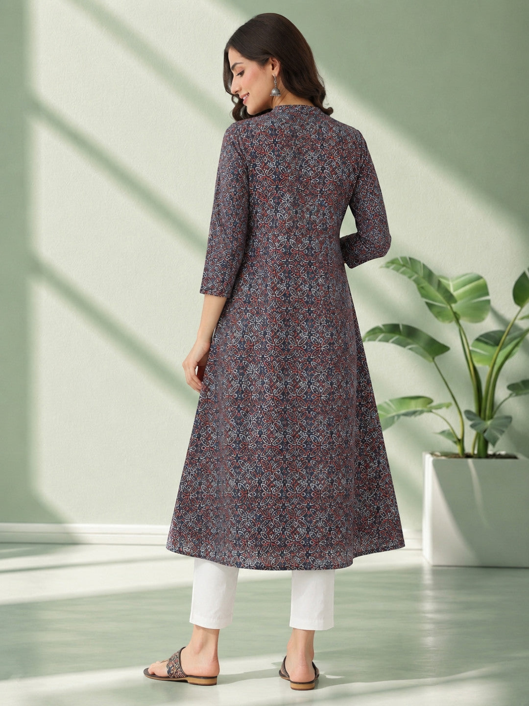 Woman wearing printed knee-length kurta with 3/4 sleeves, paired with white pants, stylish plus size fashion