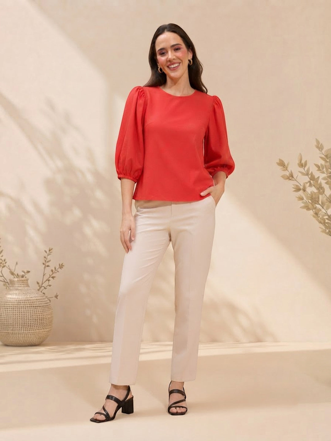 Woman in red puff sleeve top and cream pants, stylish plus size outfit