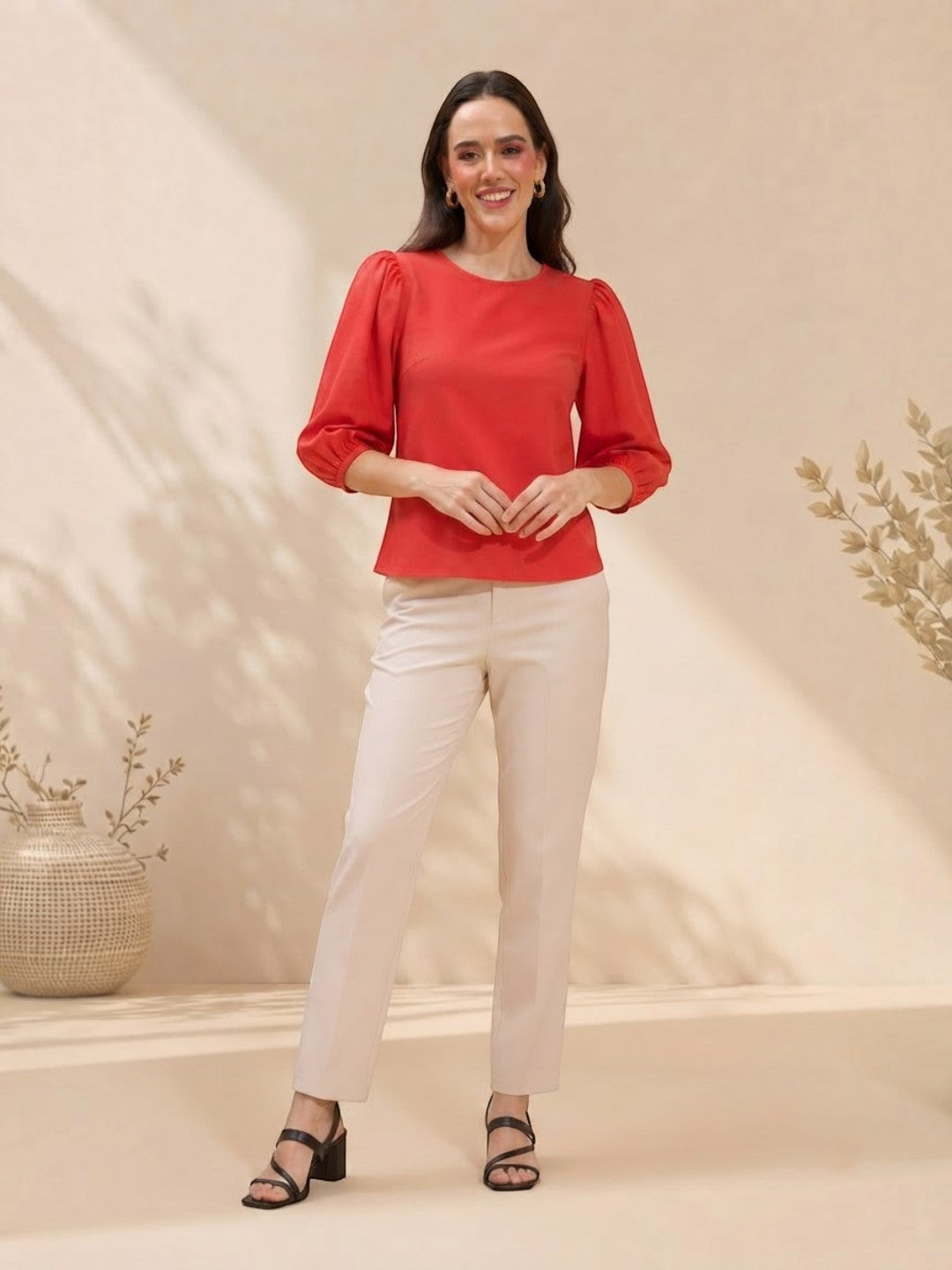 Woman in red puff sleeve top and cream pants, stylish plus size fashion outfit