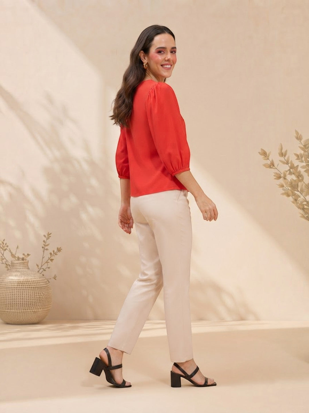 Woman in red puff-sleeve top and cream pants, stylish plus size outfit for everyday wear