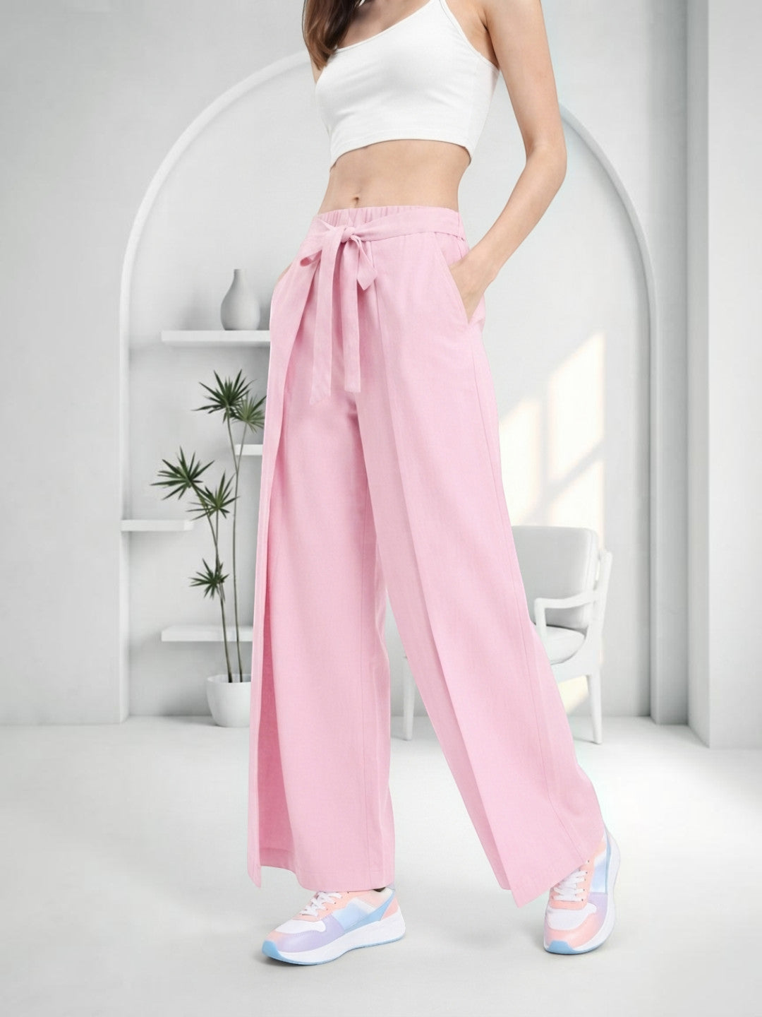 Pink wide-leg pants with tie waist, styled with white crop top and pastel sneakers for casual women's fashion