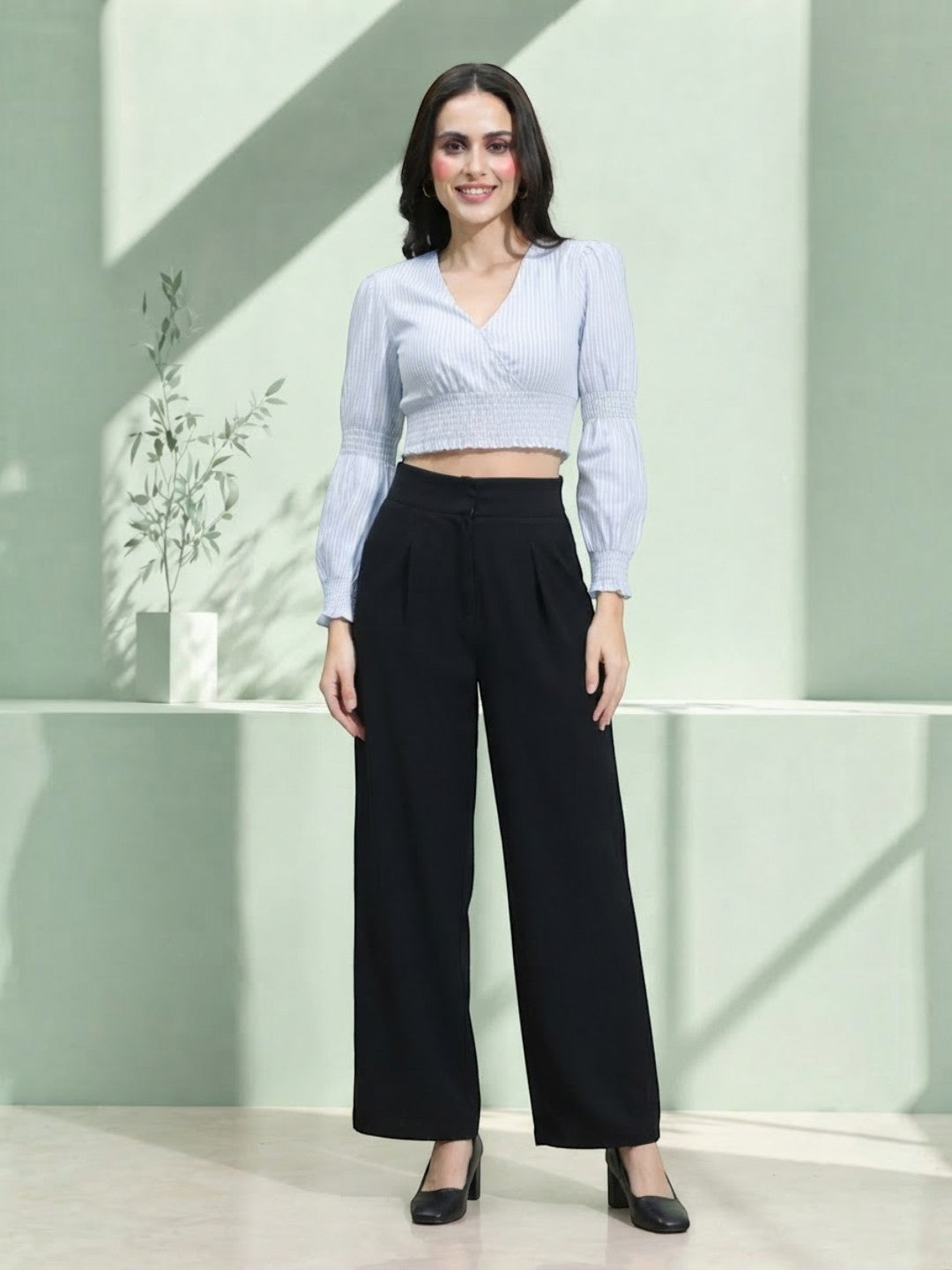 Woman in striped crop top and black wide-leg pants, stylish plus size fashion outfit
