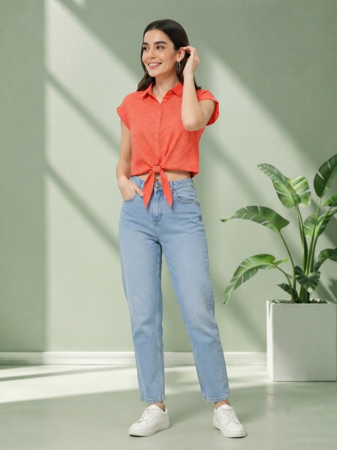Woman in coral tie-front crop top and light wash straight jeans, casual summer outfit