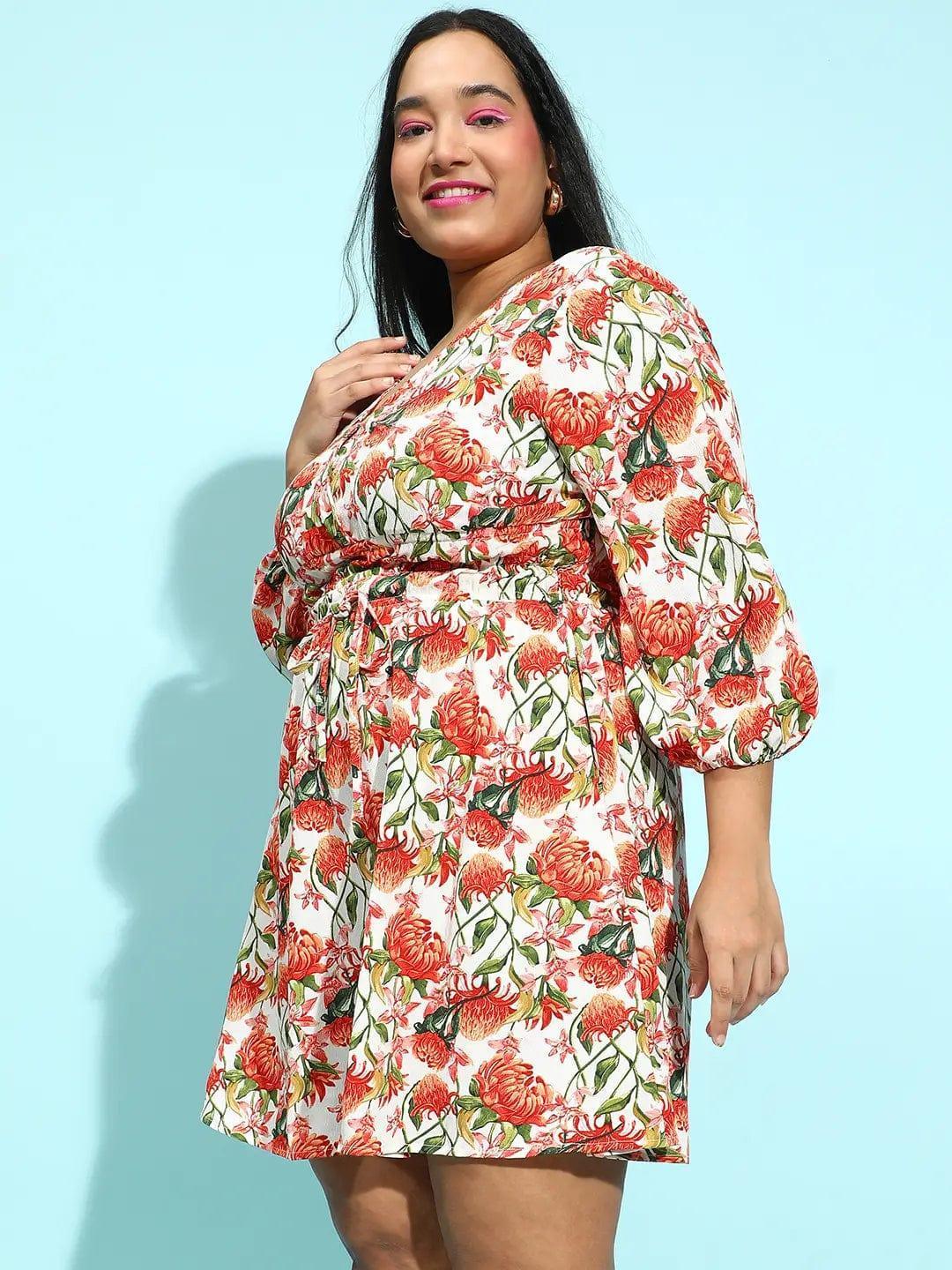 A woman wearing a white dress with a floral print, smiling at the camera.