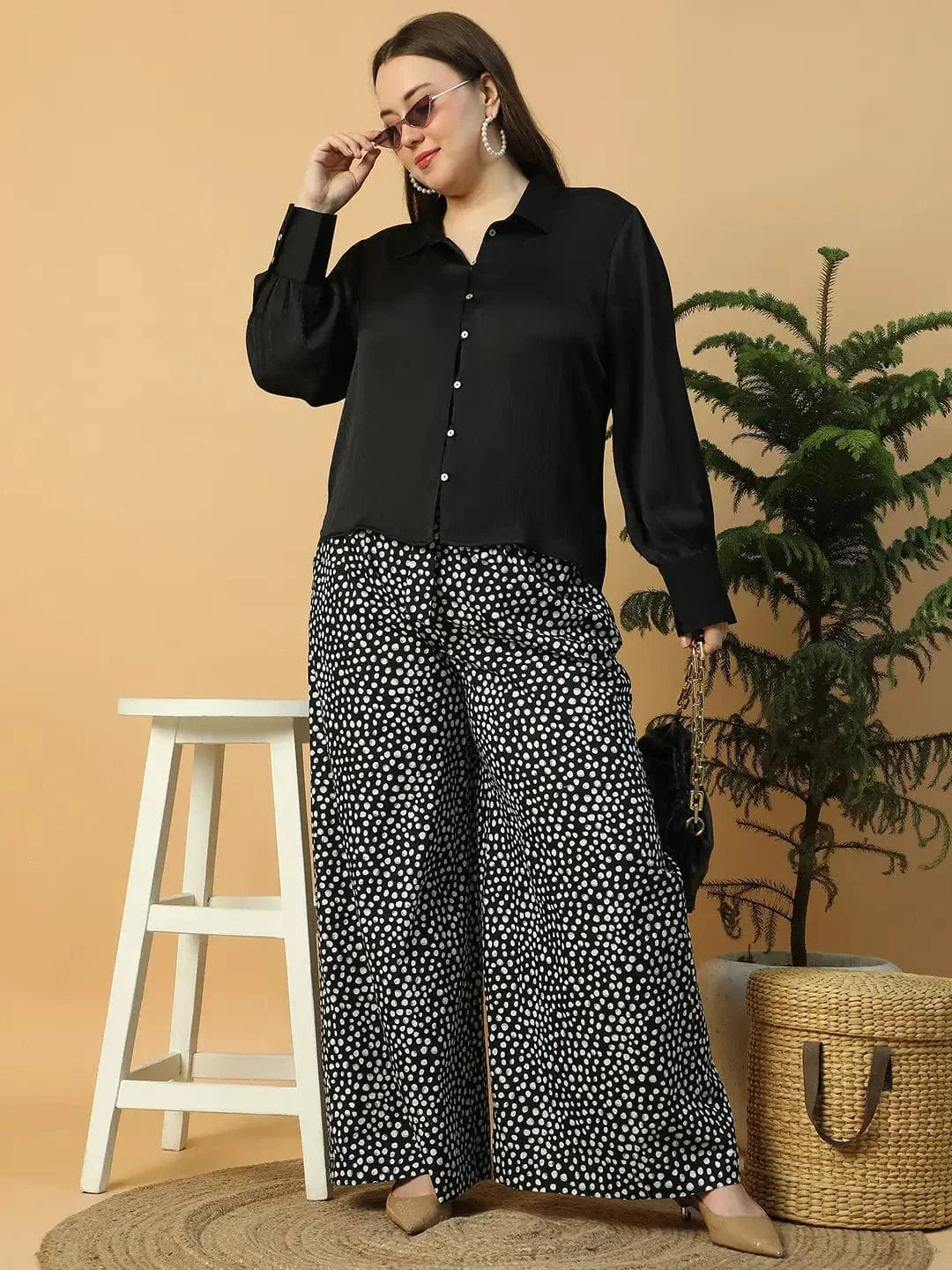 A person wearing wide-leg pants with a black and white polka dot pattern.