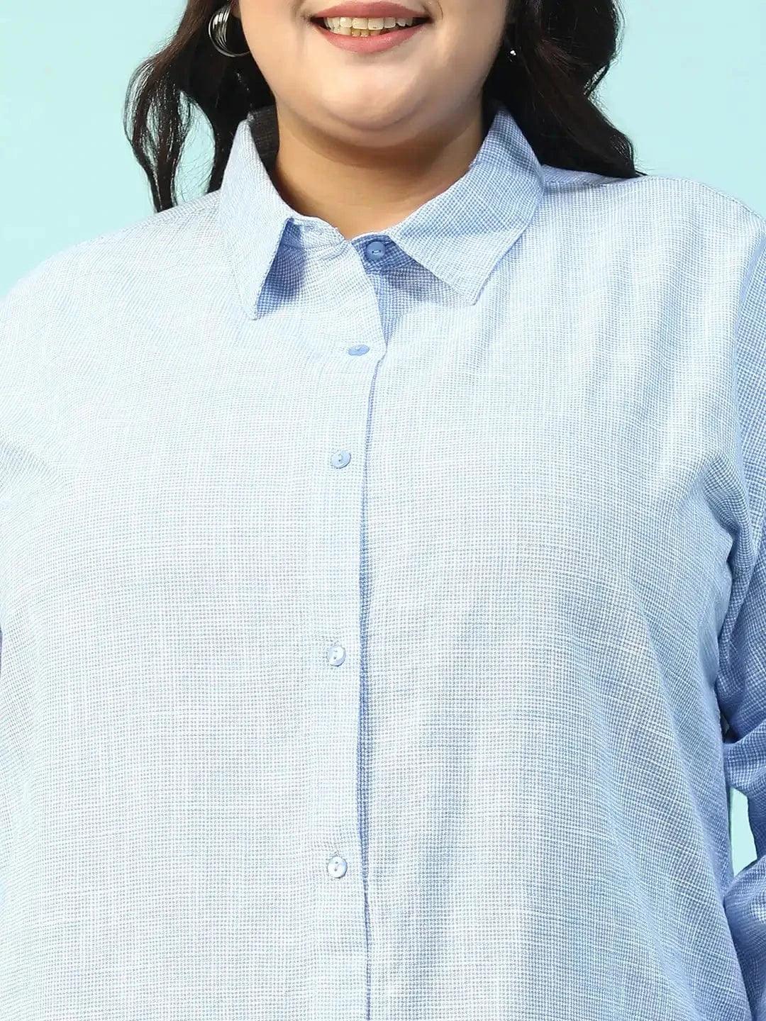 A smiling woman with long dark hair wearing a light blue button-up shirt.