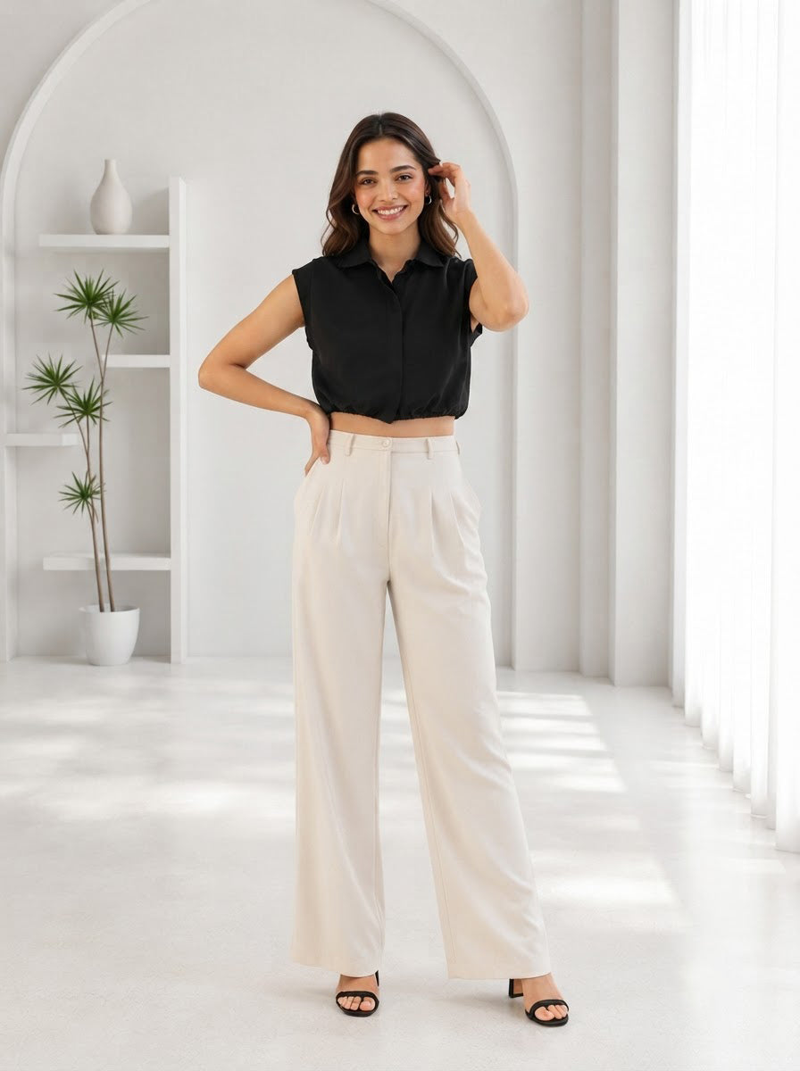 Woman in black sleeveless crop top and cream wide-leg pants, stylish plus size fashion outfit