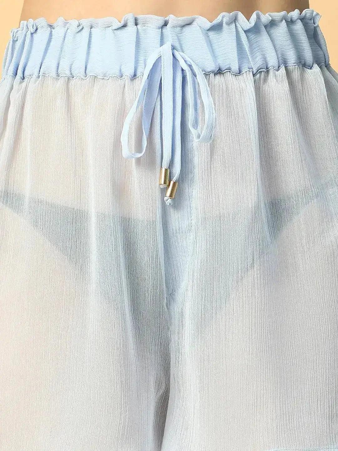 A woman wearing a pair of white shorts with a ruffled waistband.