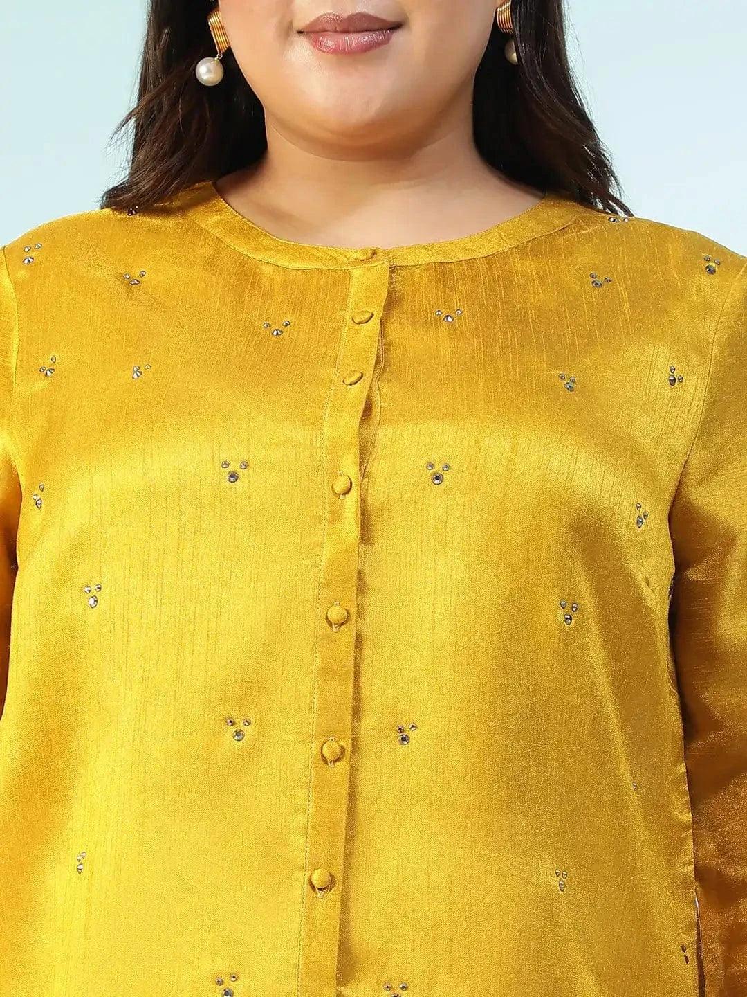A woman wearing a yellow blouse with small embroidered designs, posing for a photograph.