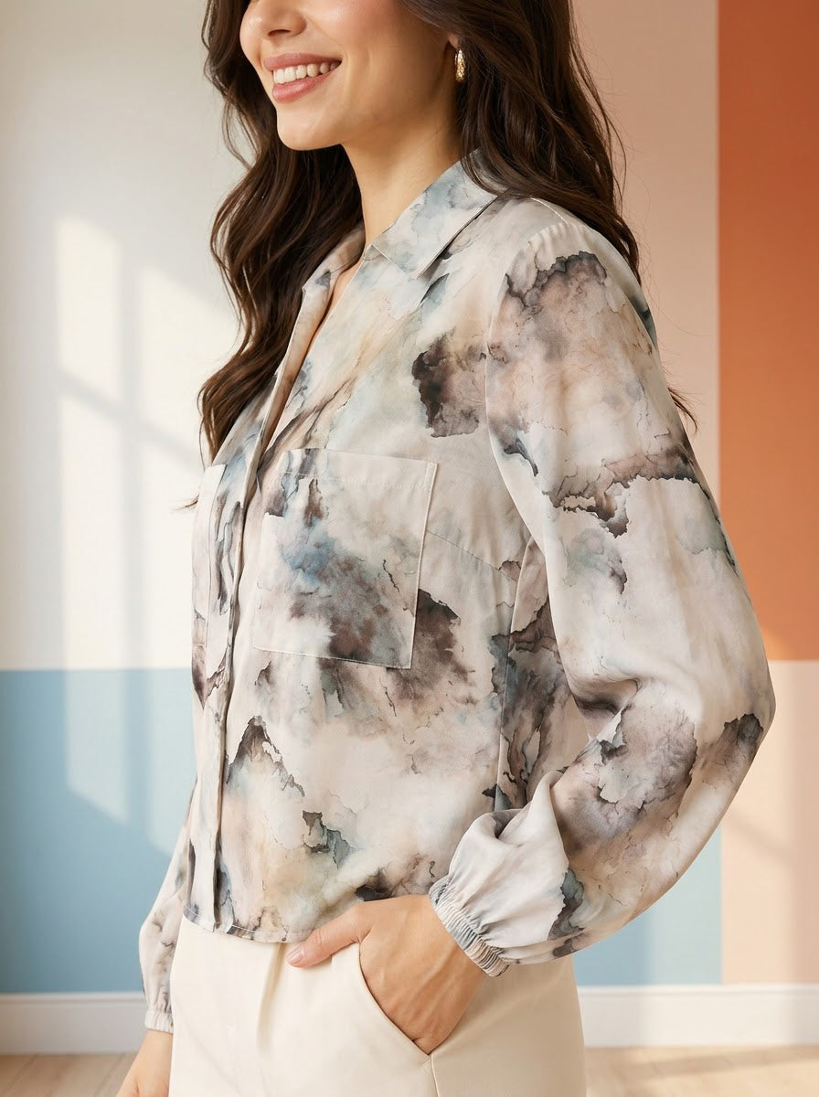 Woman wearing abstract print blouse with long sleeves and chest pocket, plus size fashion