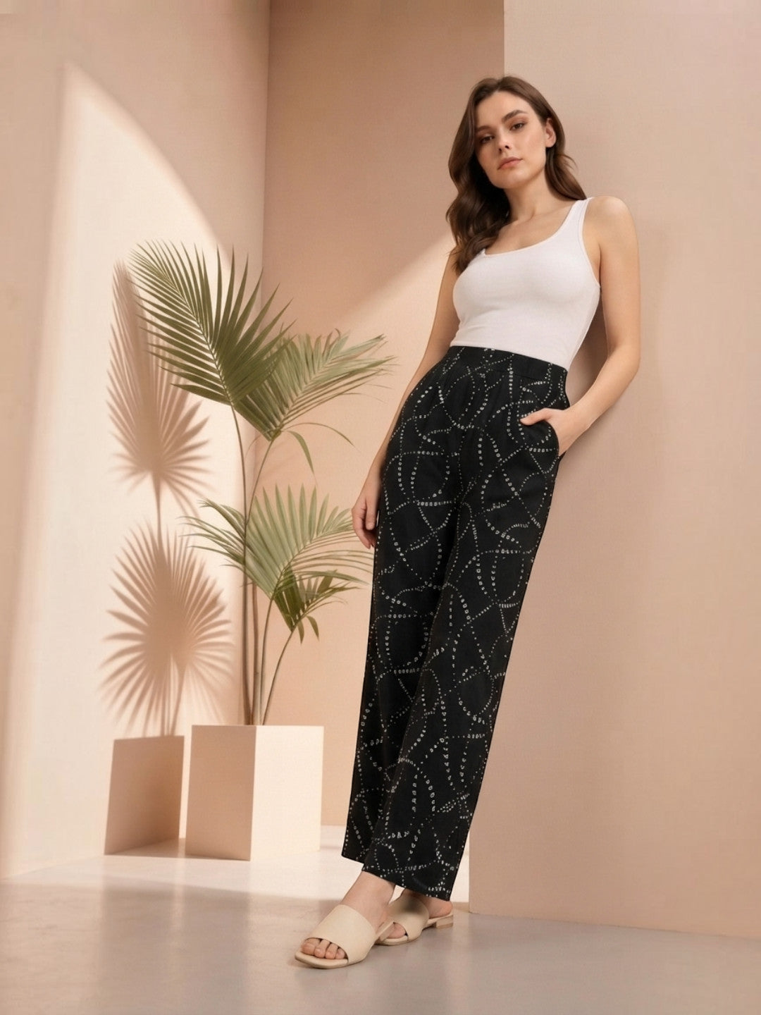 Woman in black patterned wide-leg pants with white tank top, stylish plus size fashion