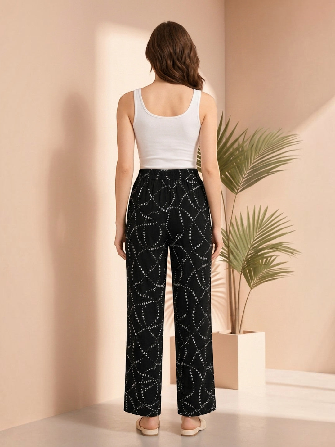 Black wide-leg pants with white geometric dot pattern, paired with white tank top, stylish plus size fashion