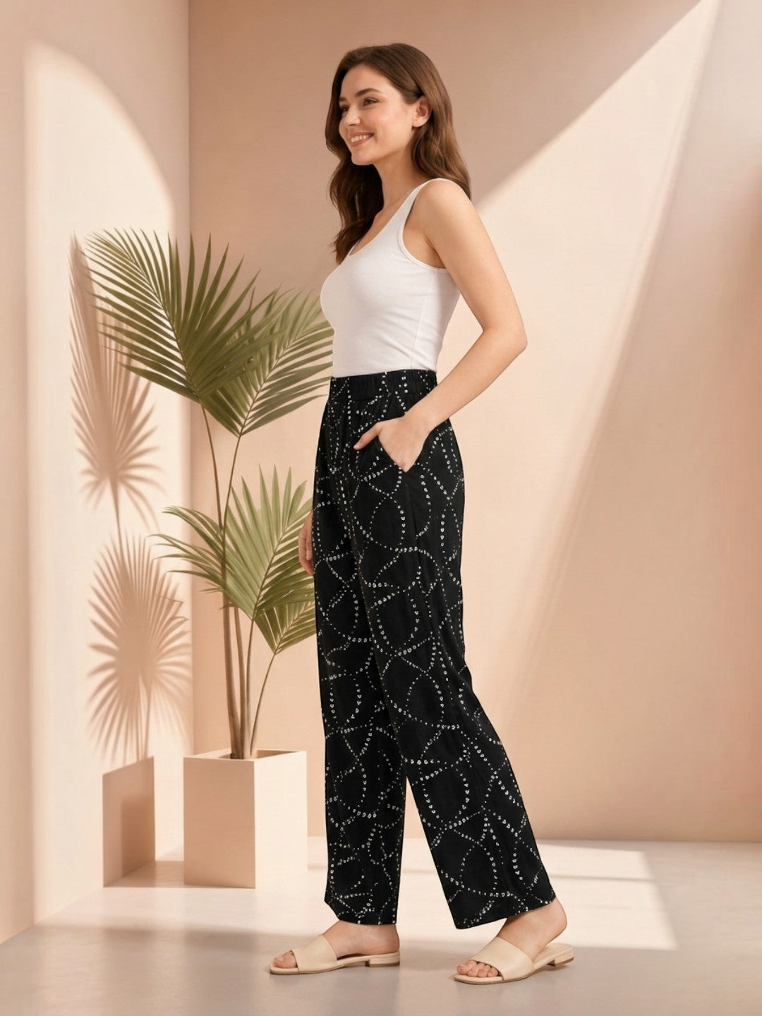 Woman in black patterned wide-leg pants with white top, stylish plus size fashion