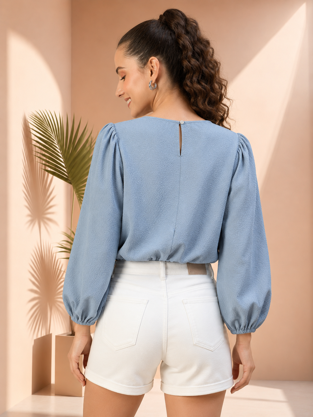 Woman in light blue puff sleeve top and white denim shorts, back view, plus size fashion