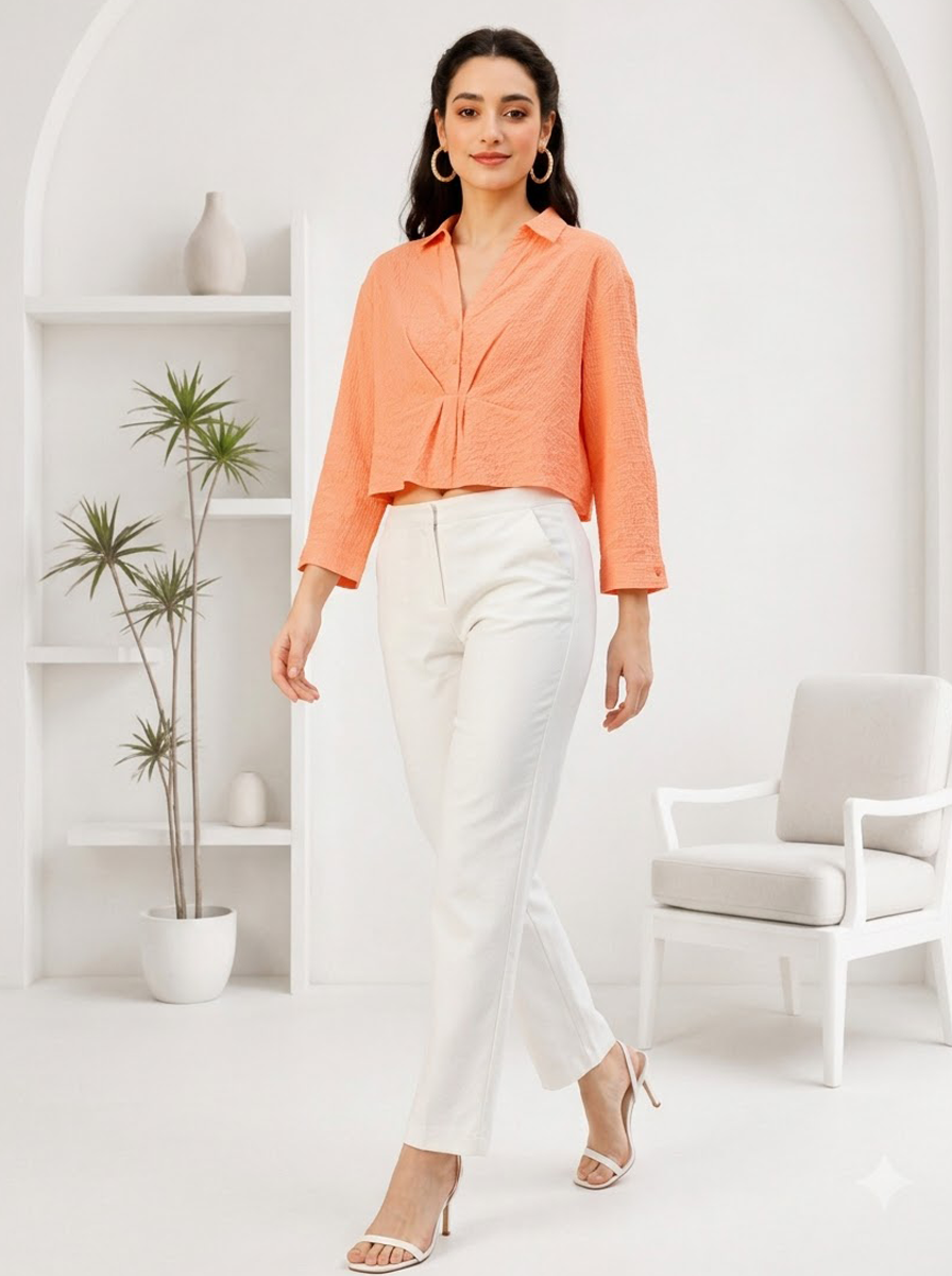 Woman in orange cropped blouse and white pants, stylish plus size outfit for casual wear