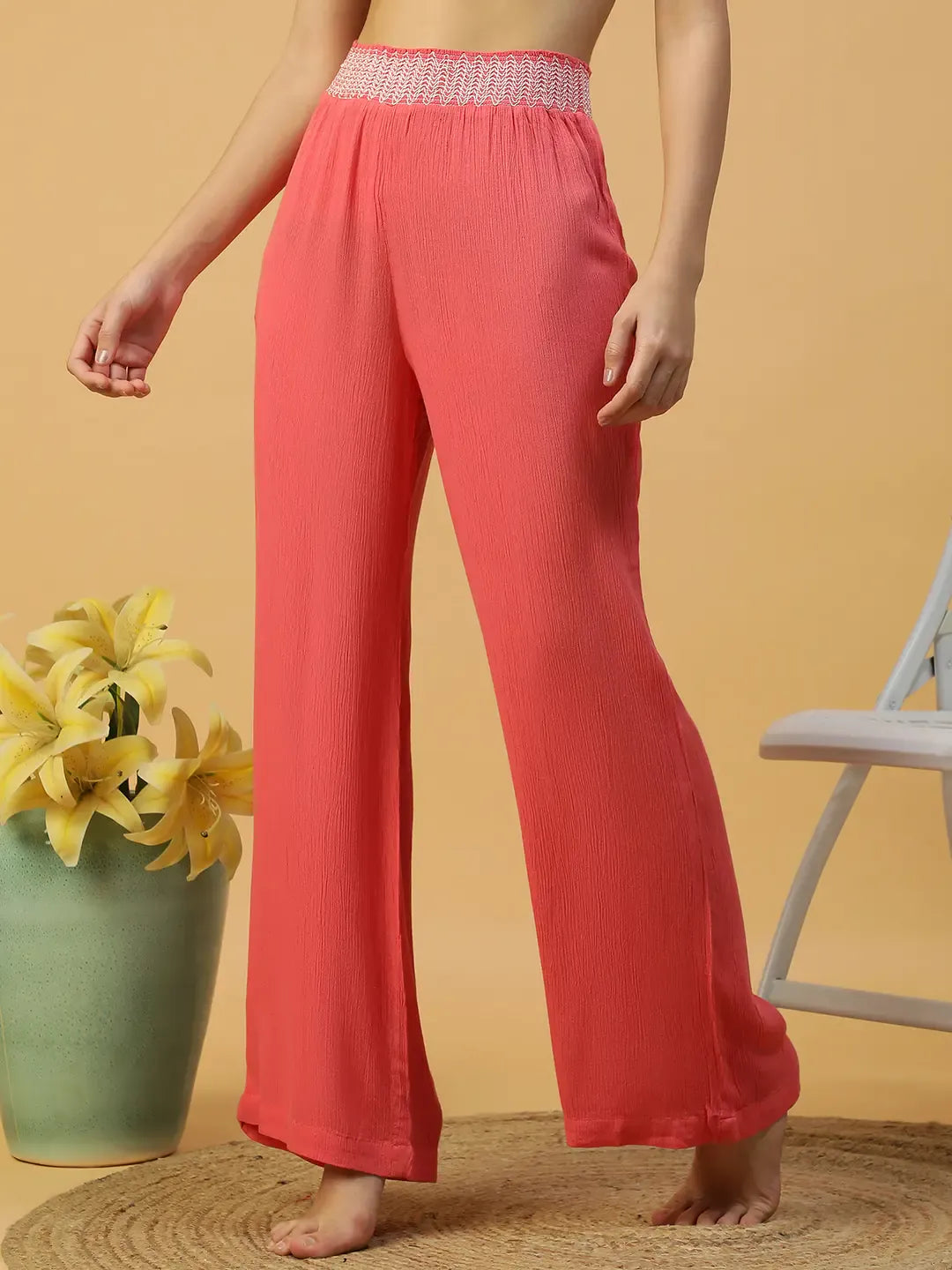 A woman wearing bright red wide leg pants.