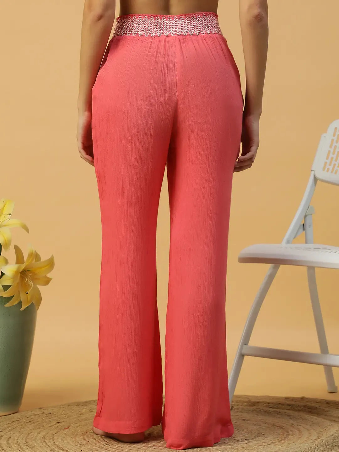 A woman wearing bright red wide leg pants.