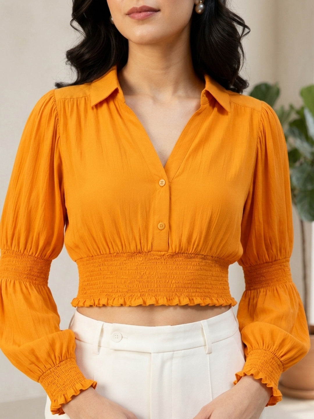 Mustard yellow cropped blouse with puff sleeves and smocked waist, paired with white pants