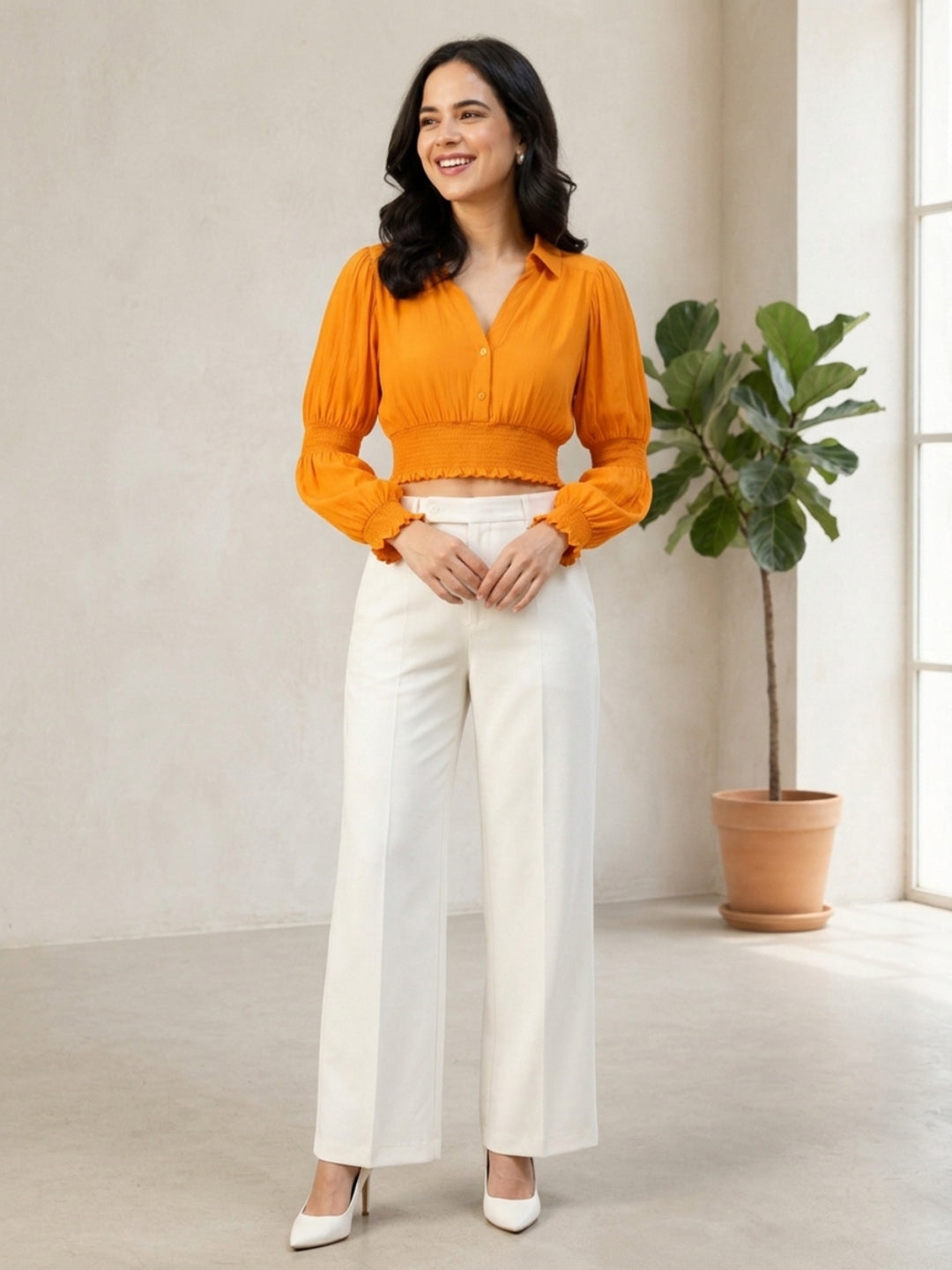 Woman in orange cropped blouse with puff sleeves and white wide-leg pants, stylish plus size fashion outfit