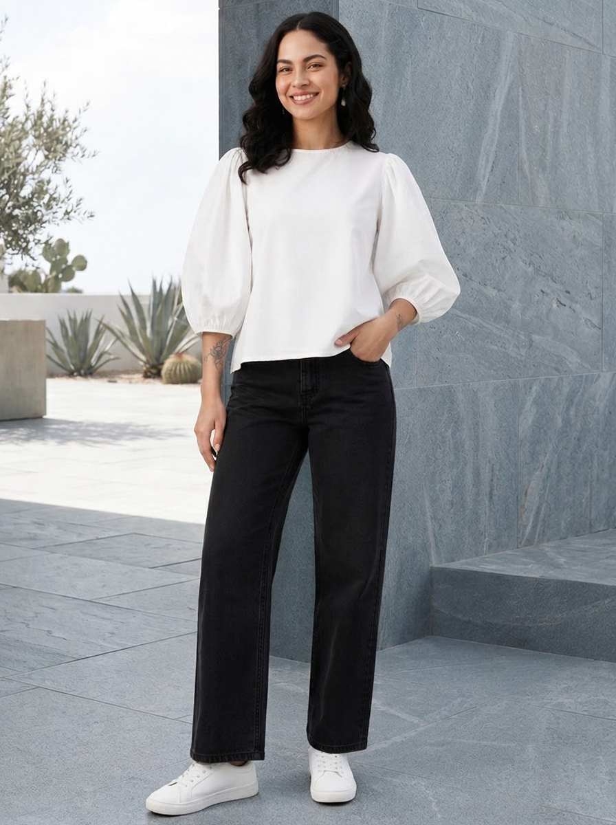 Woman in white puff sleeve top and black wide leg jeans, stylish plus size outfit