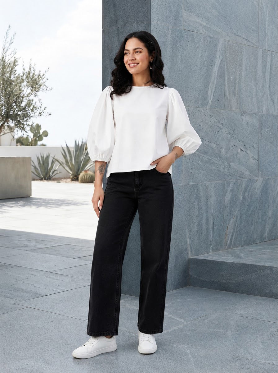 Woman in white puff sleeve top and black wide leg jeans, stylish plus size fashion outfit