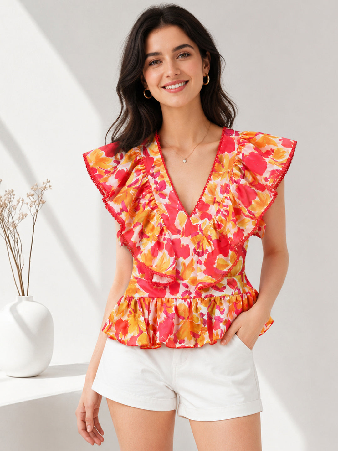 Floral ruffle top with V-neck and peplum hem, paired with white shorts for summer fashion