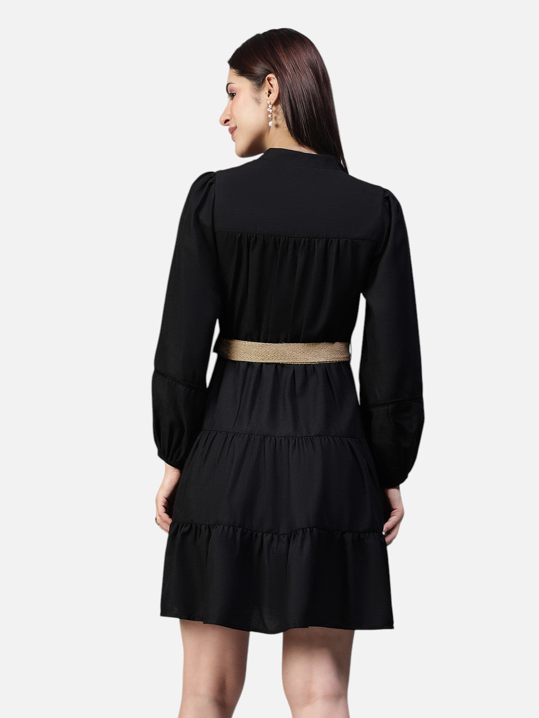 Woman modeling black long sleeve tiered dress with beige belt, shown from the back
