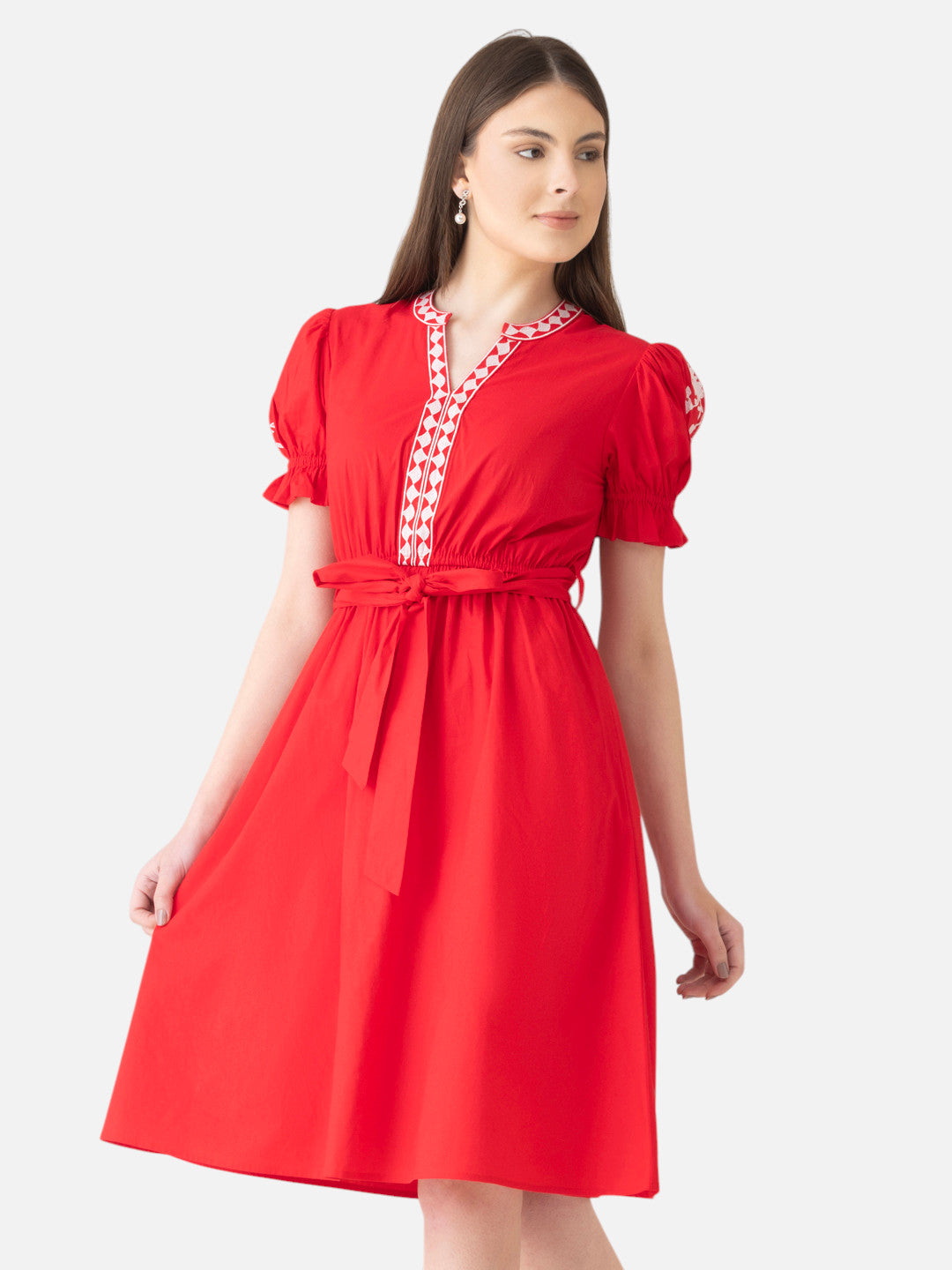 Woman wearing a knee-length red short sleeve dress with printed V-neck and waist tie