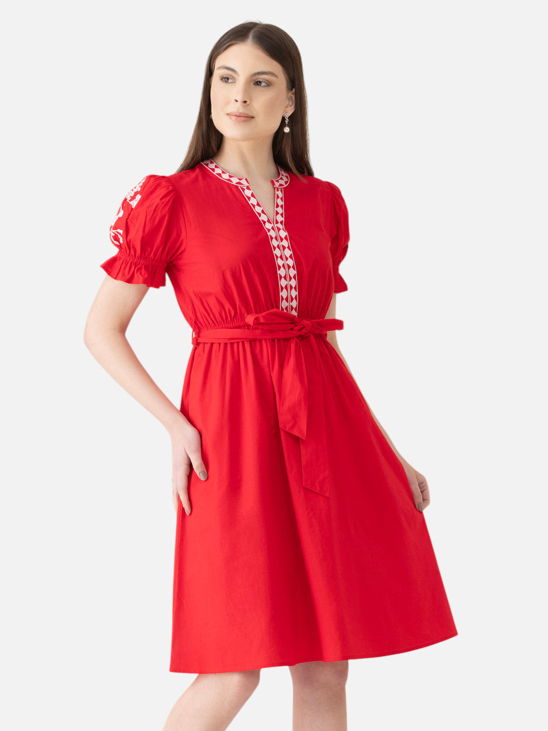 Woman wearing a red knee-length dress with puff sleeves and a matching waist tie