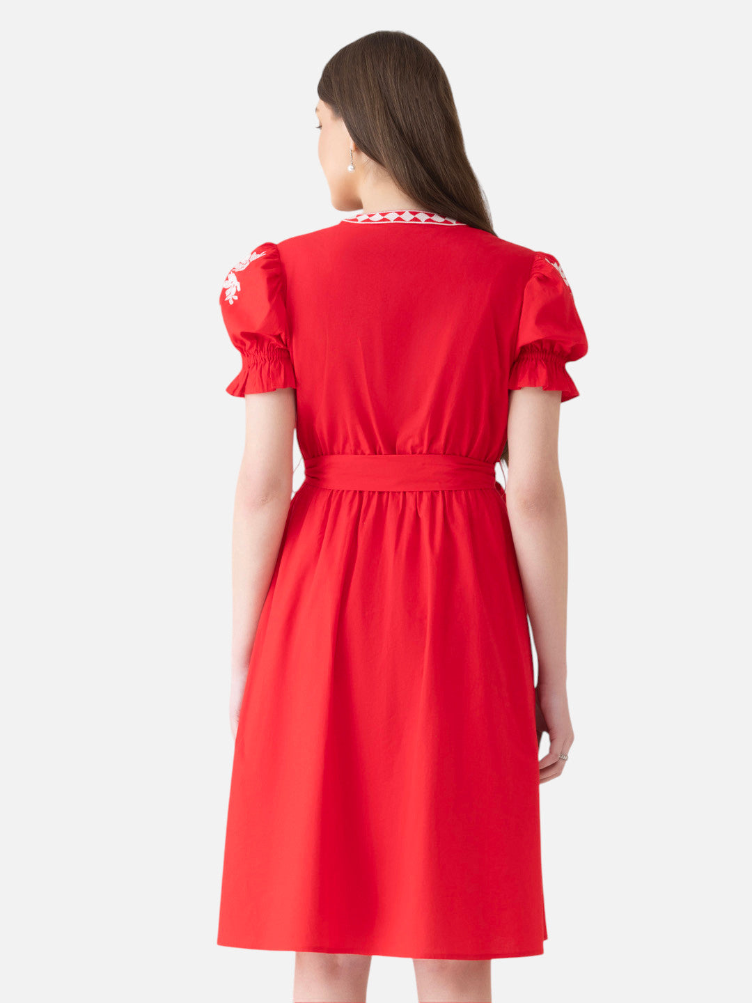 Back view of woman wearing knee-length red short sleeve dress with puff sleeves and embroidered collar
