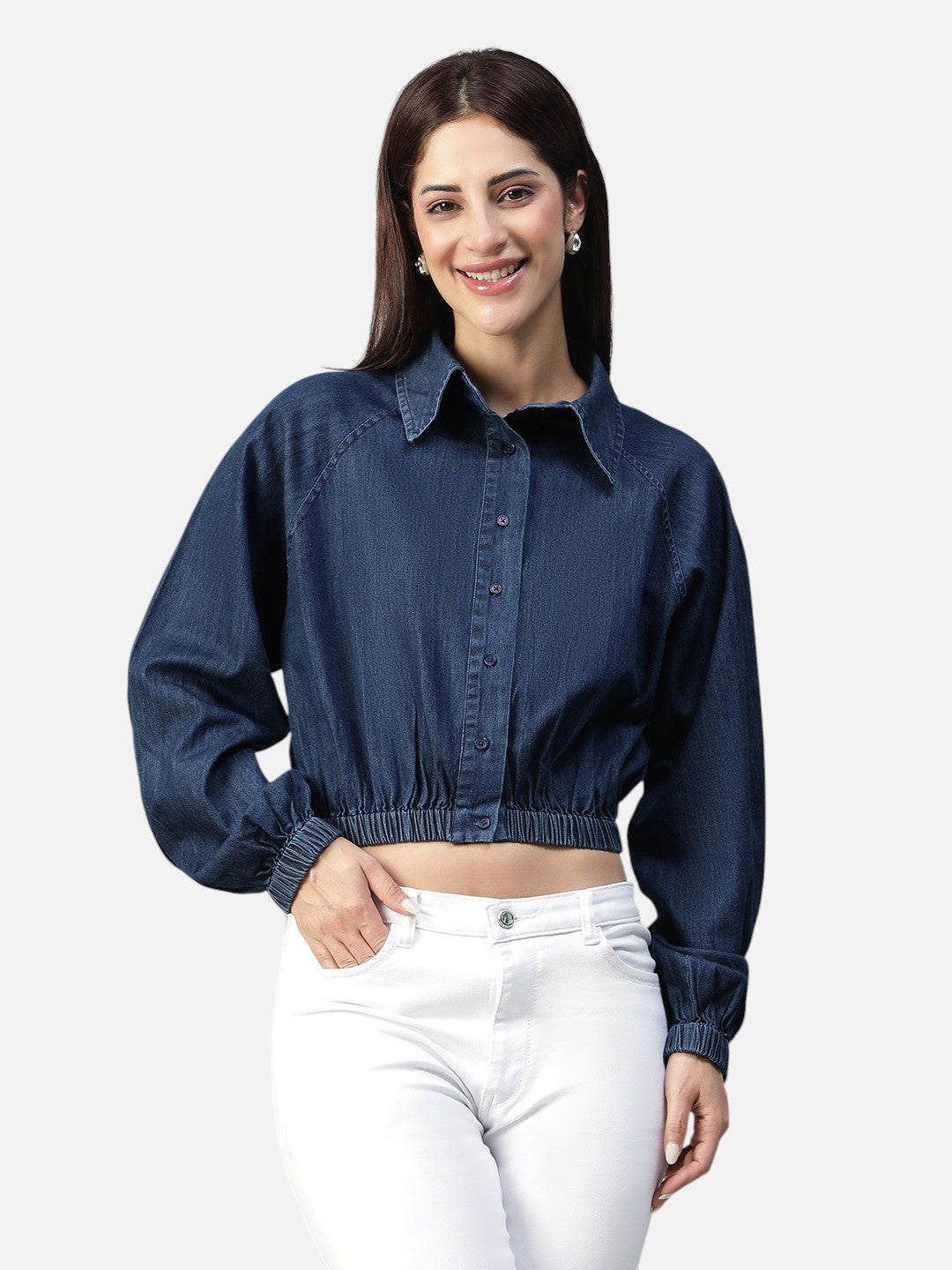Woman modeling a blue denim cropped shirt with long sleeves and white jeans