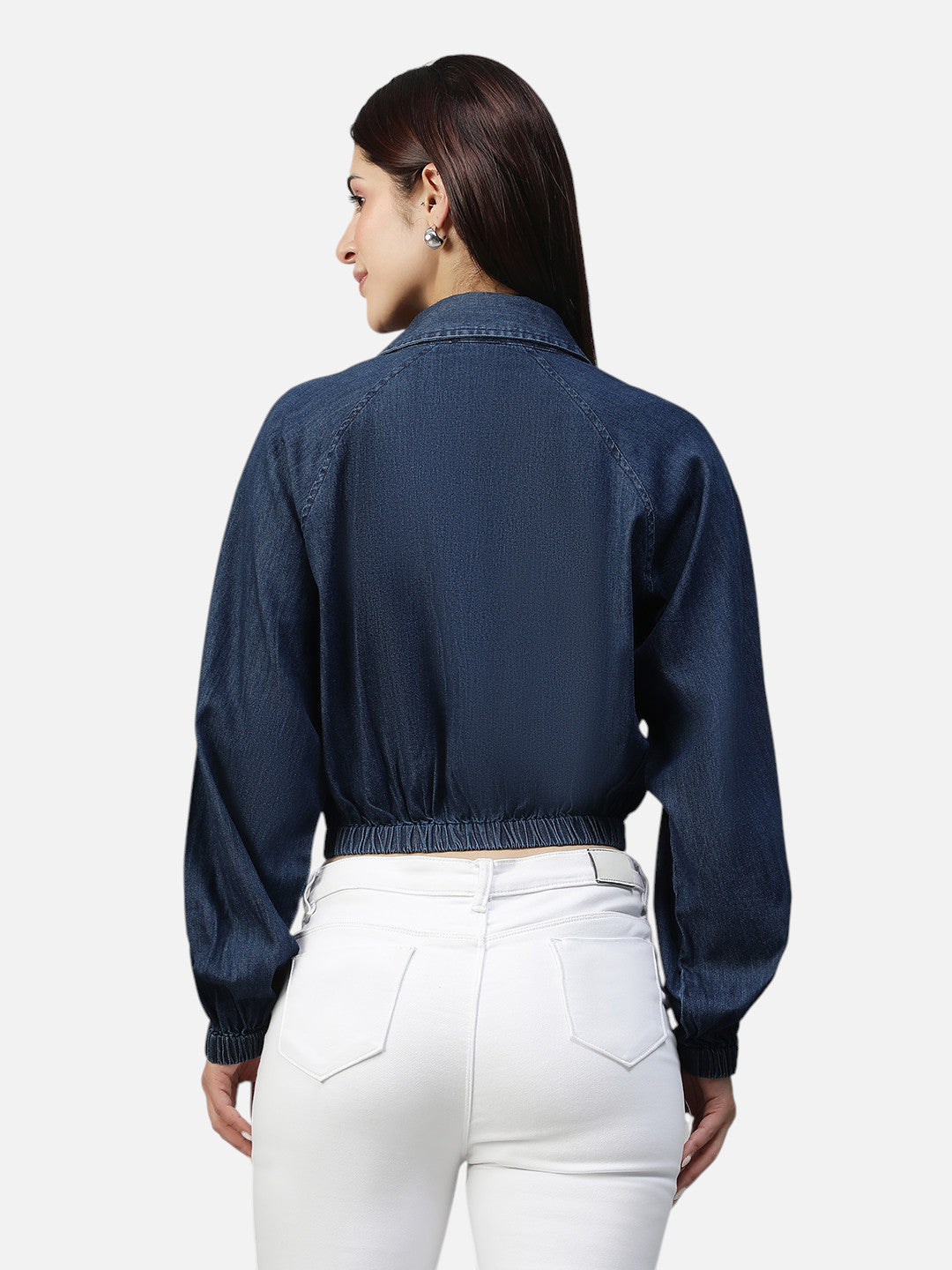 Woman wearing dark blue cropped jacket with elastic hem and white fitted jeans, back view