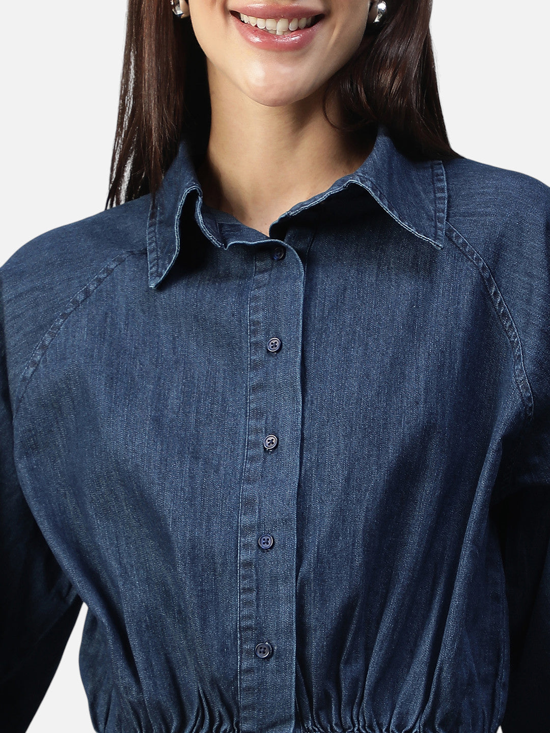Close-up of woman wearing a blue denim button-down shirt with pointed collar