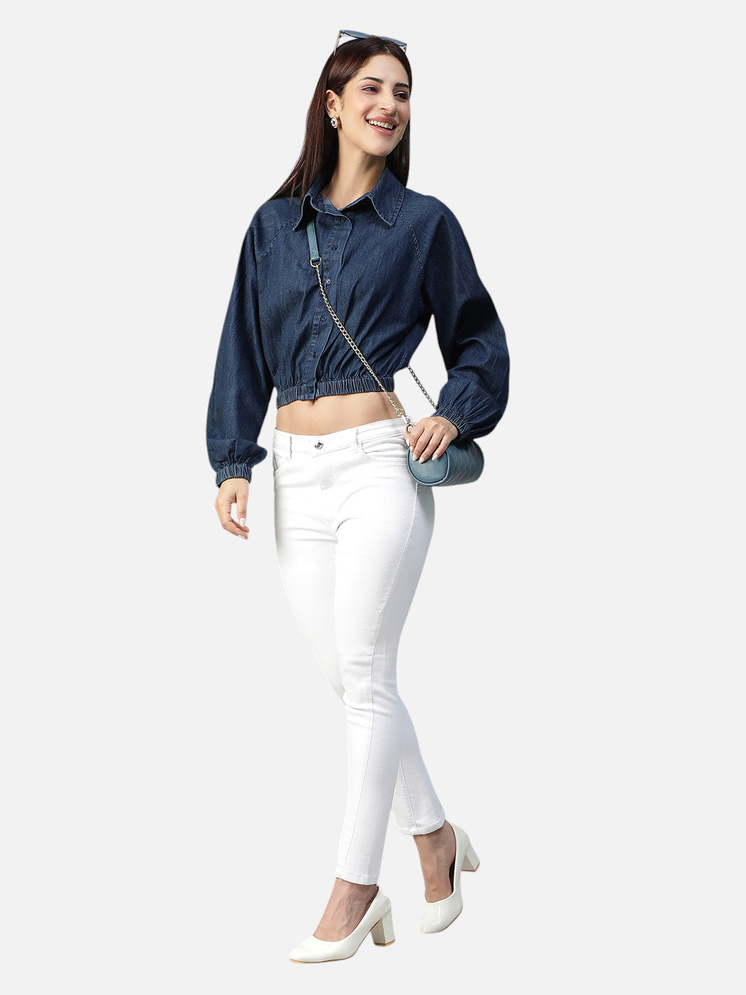 Woman in dark blue cropped denim shirt and white skinny jeans with white heels