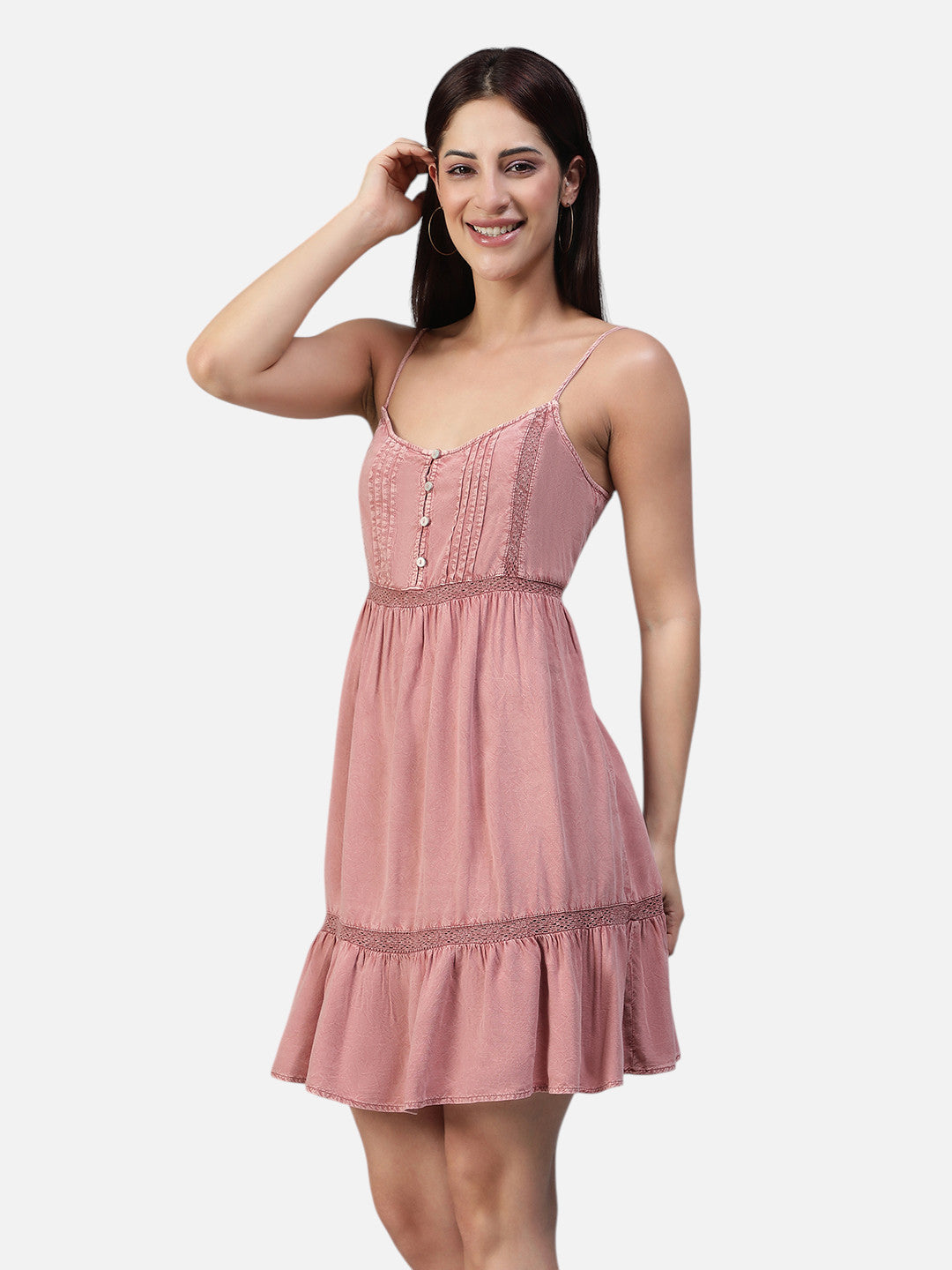 Woman wearing a sleeveless pink mini dress with spaghetti straps and lace details