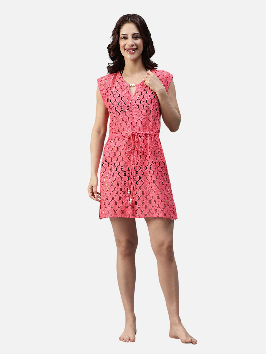 Woman in pink crochet short dress with drawstring waist and cap sleeves on white background