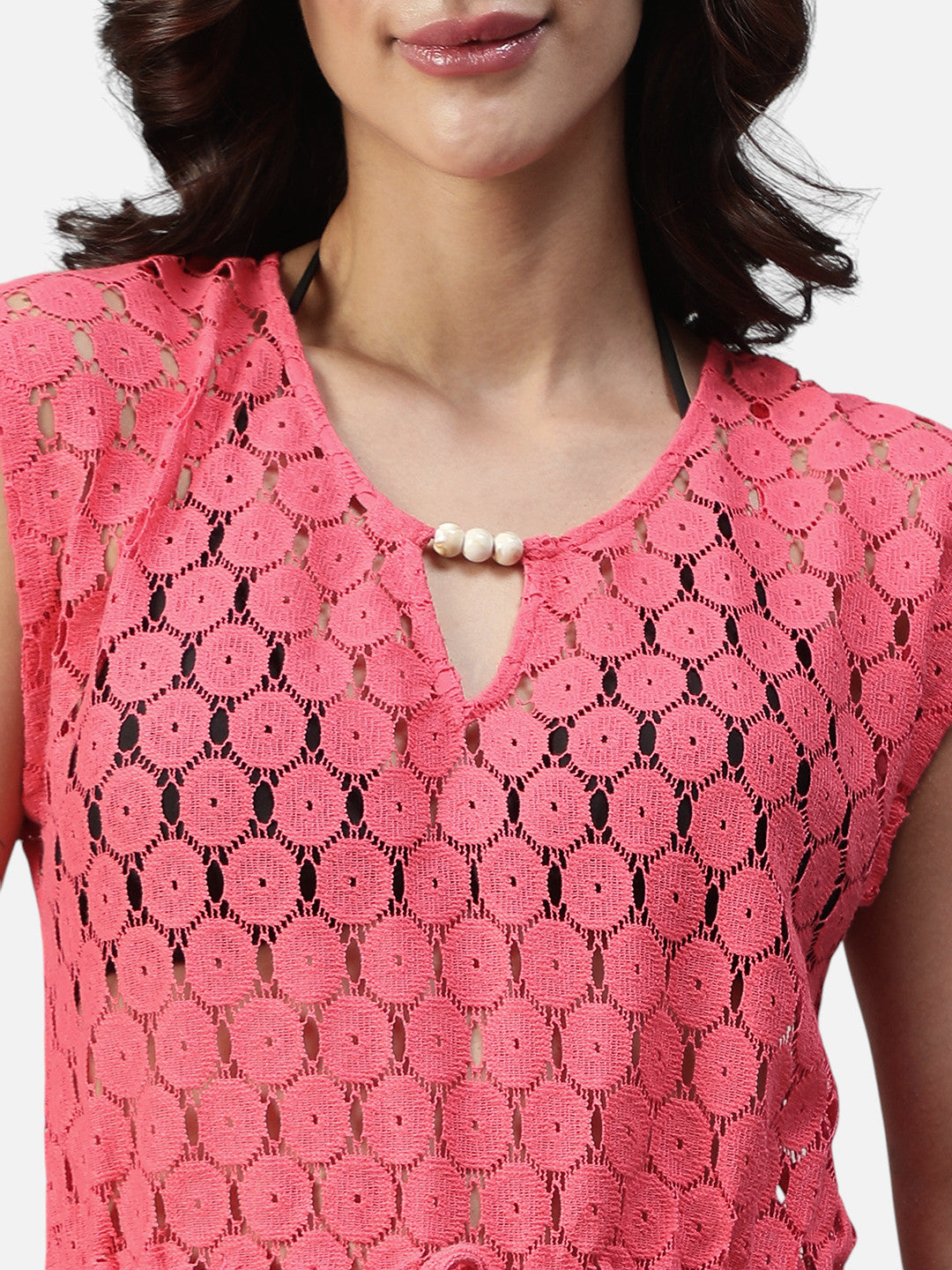 Pink crochet lace top with cap sleeves and pearl button detail at neckline