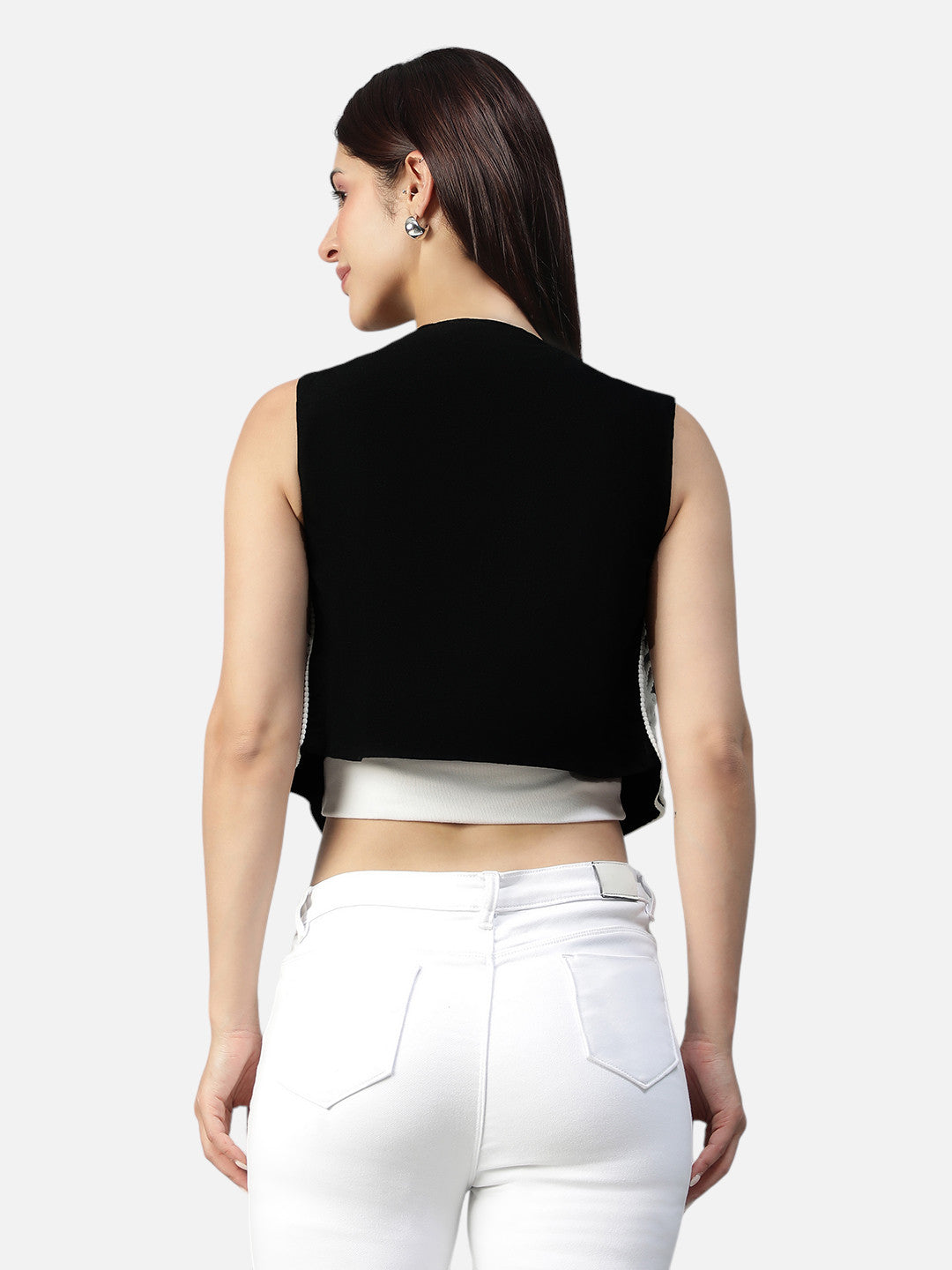Woman in a black sleeveless crop top and white high-waisted jeans, back view
