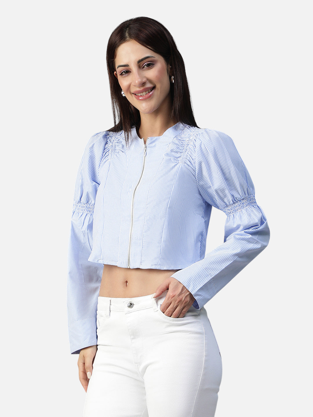 Woman wearing a blue striped crop top with zipper and long sleeves, paired with white jeans