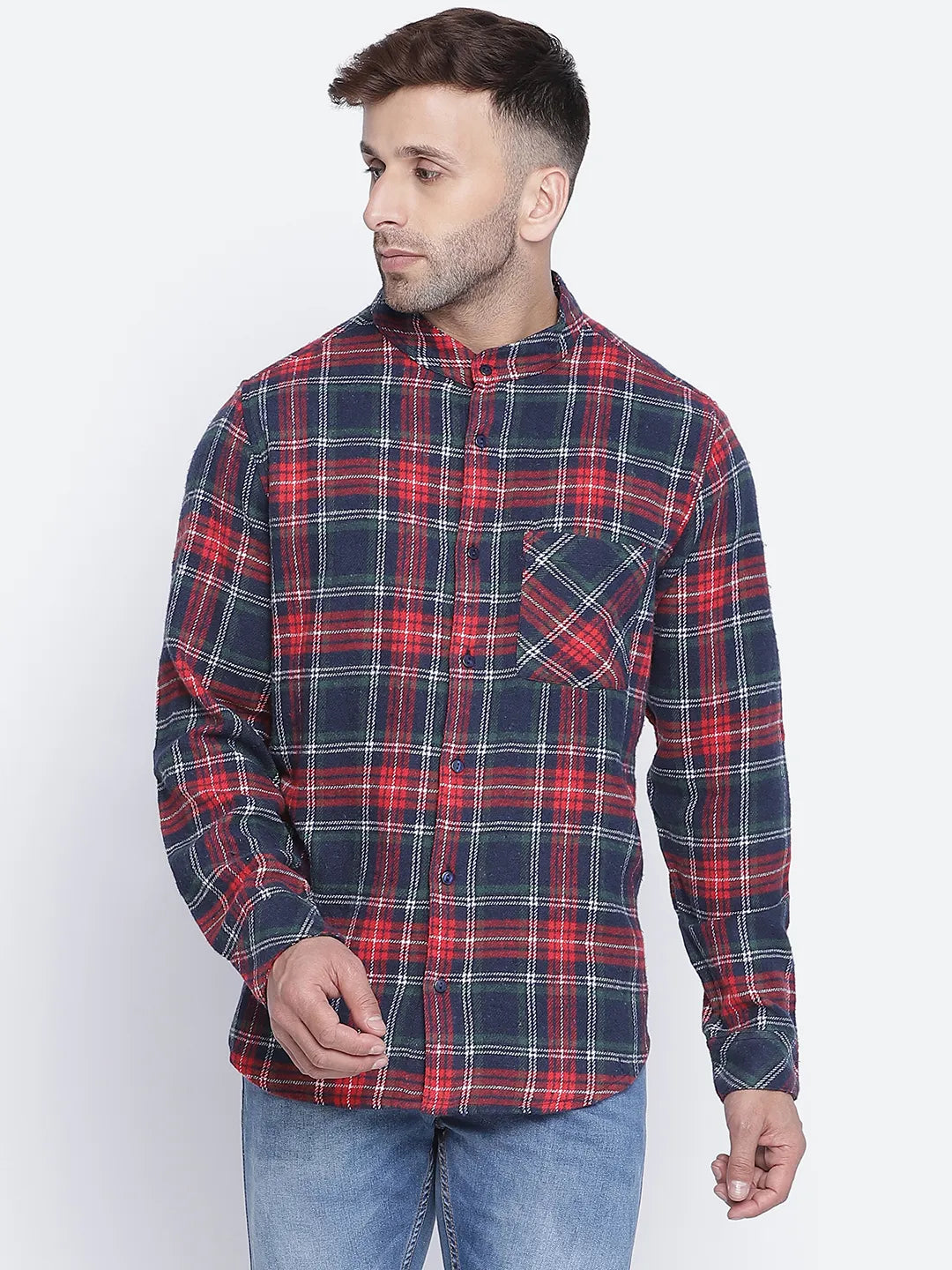 A man wearing a red and blue plaid button-up shirt with a pocket, standing against a white background.