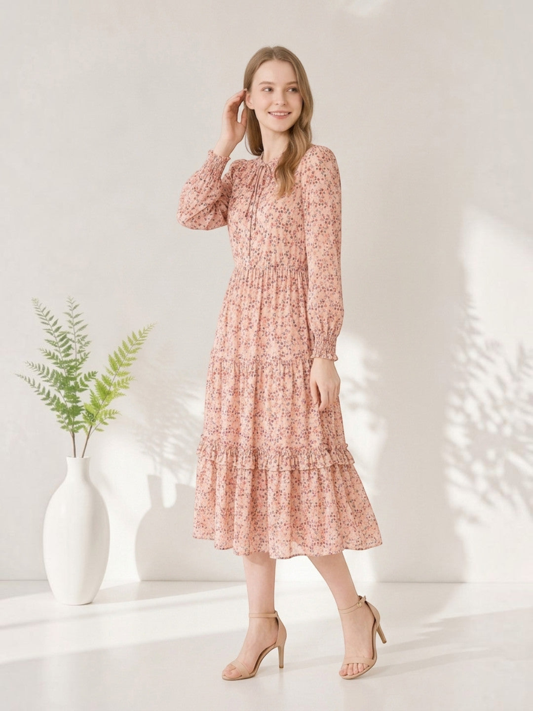 Pink floral midi dress with ruffles, long sleeves, and tie neck, styled with heels for women's fashion