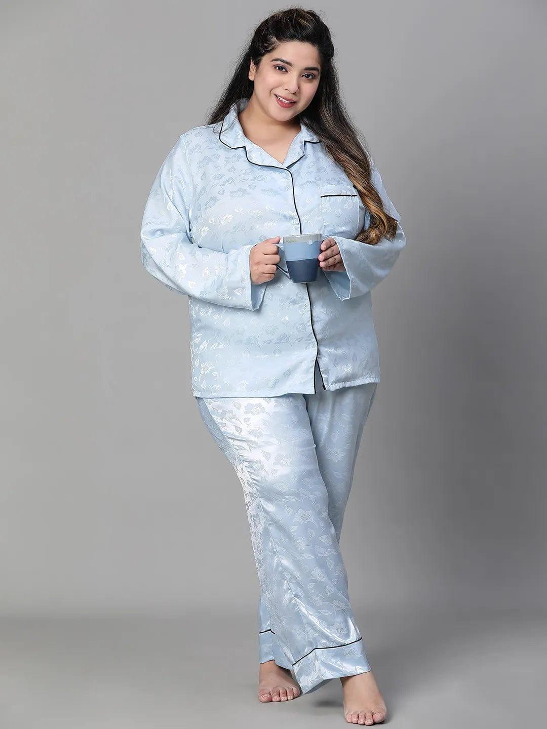 A woman wearing a light blue pajama top and matching pants, standing against a white background.