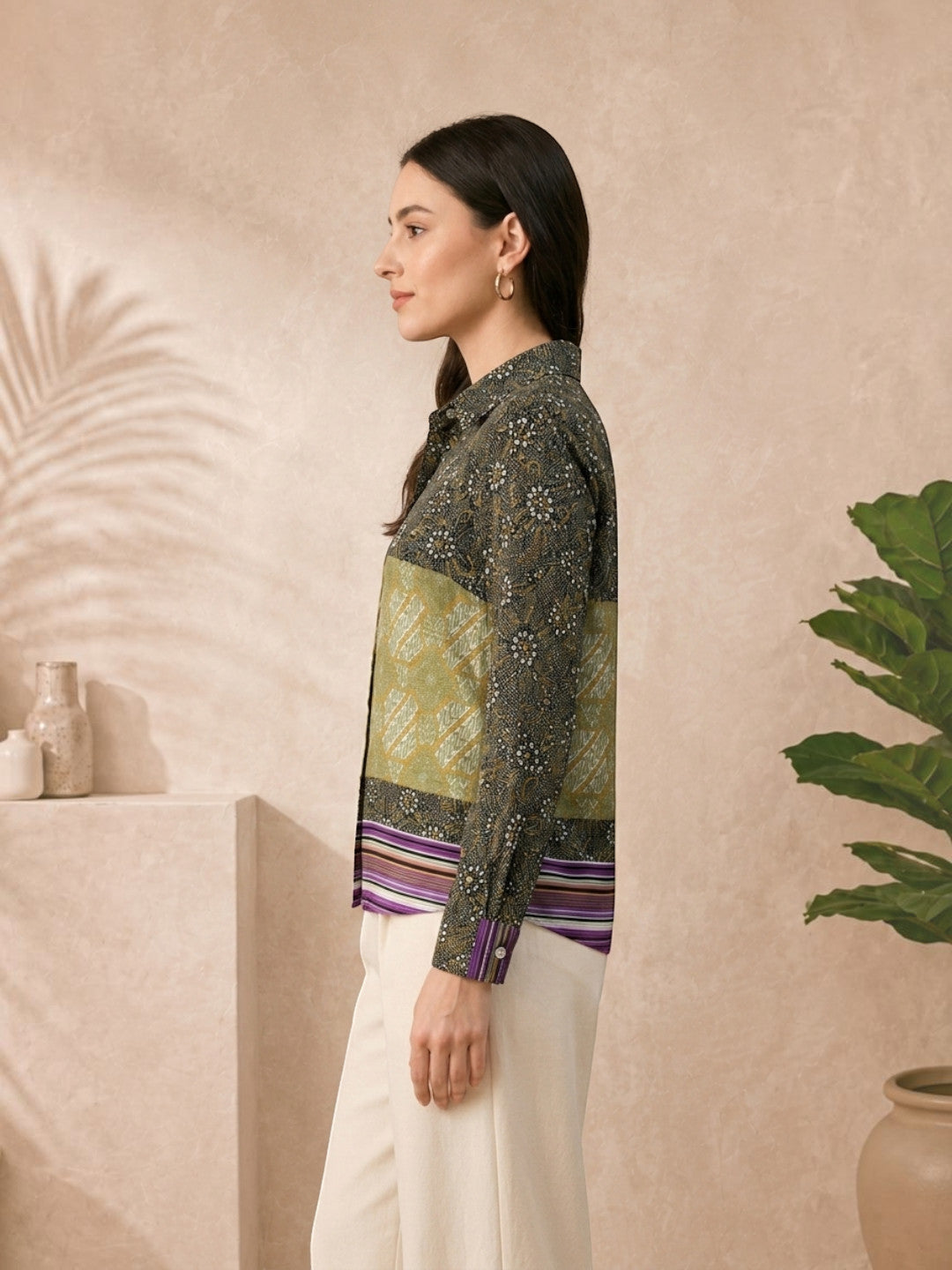 Woman in floral patterned blouse with striped hem, paired with cream pants, plus size fashion