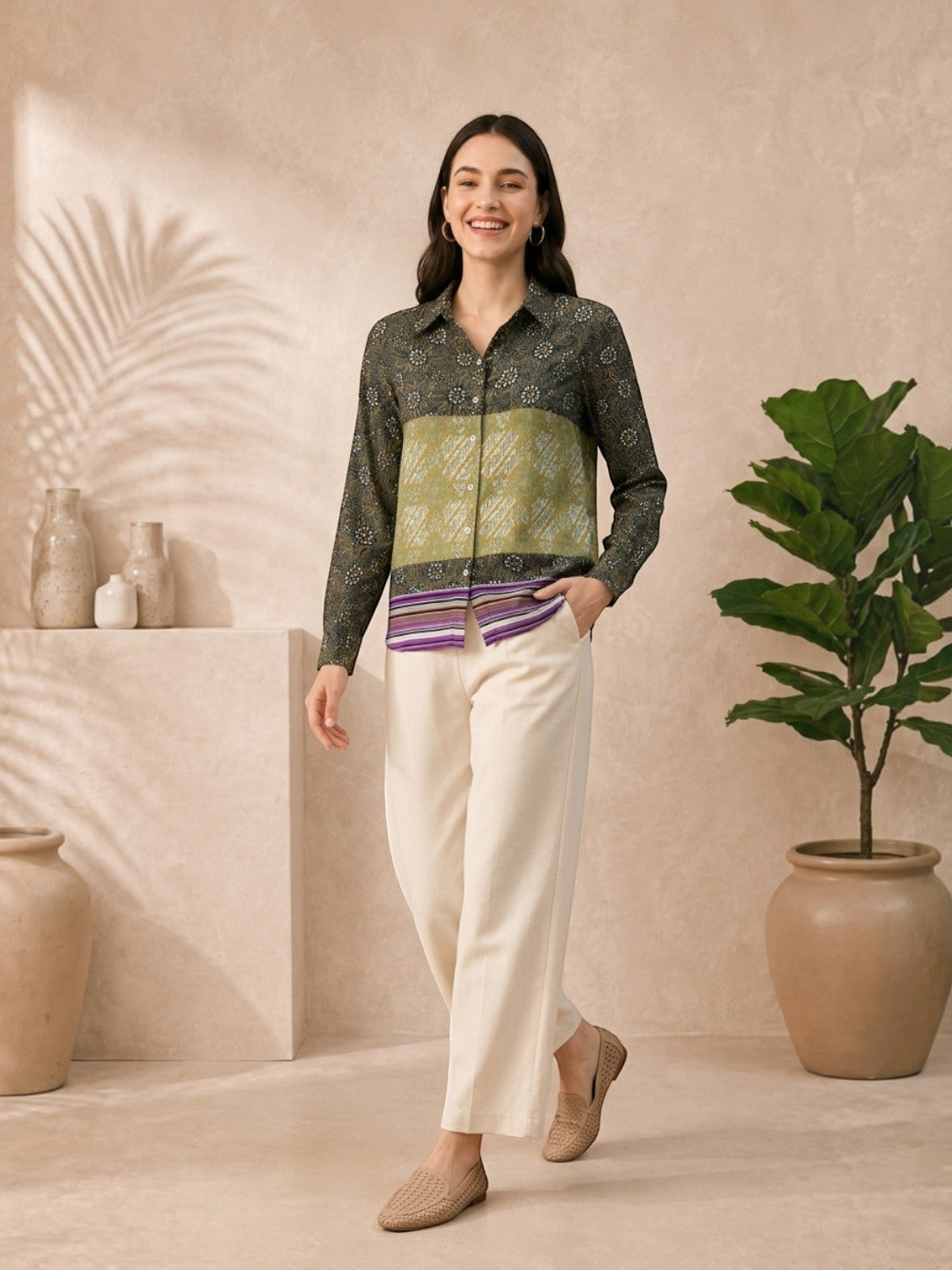 Woman in floral print blouse with color-block design, paired with cream wide-leg pants and woven flats.