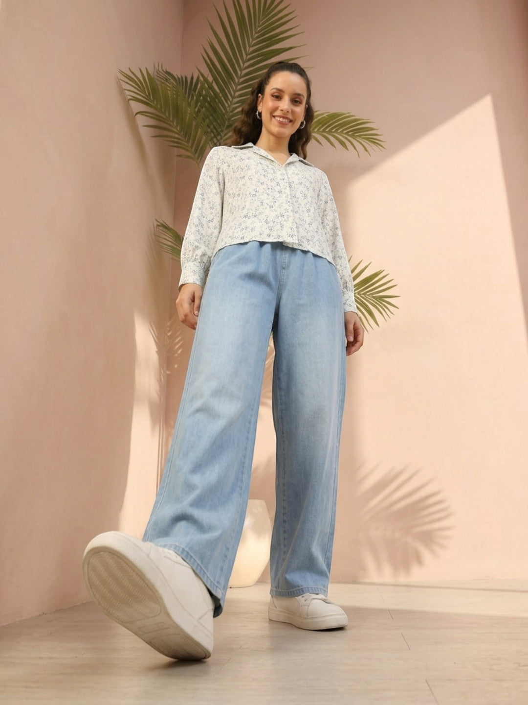 Woman in floral blouse and wide-leg jeans, stylish plus size fashion outfit